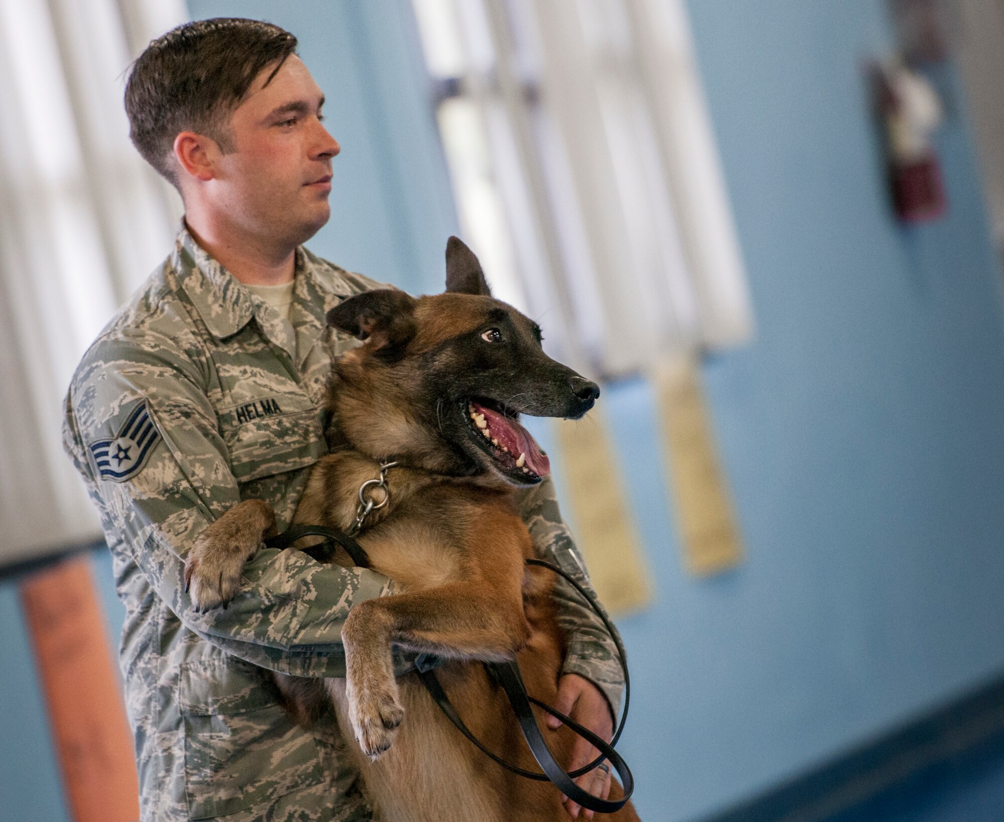 Staff Sgt. Matthew Helma and Rex, a 96th Security Forces Squadron military working dog team, share a quick hug during a demonstration for Eglin Elementary School kids May 17 at Eglin Air Force Base, Fla.  The event was in celebration of National Police Week.  More than 100 children watched two MWD teams perform obedience and attack displays.  (U.S. Air Force photo/Samuel King Jr.)
