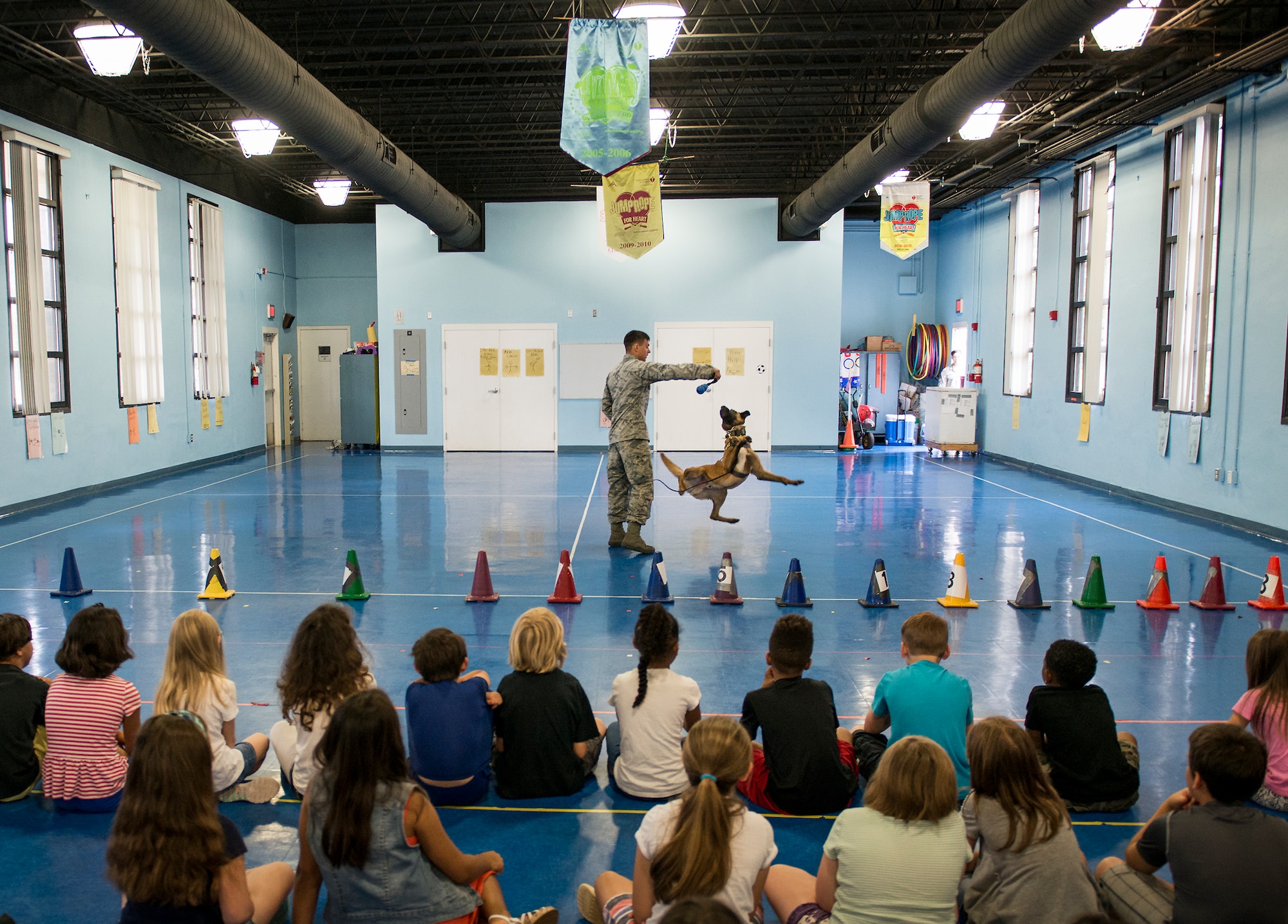 Senior Airman Chase Shankle, 96th Security Forces Squadron, puts on a military working dog demonstration with Arko for Eglin Elementary School kids May 17 at Eglin Air Force Base, Fla.    More than 100 children watched two MWD teams perform obedience and attack displays.  (U.S. Air Force photo/Samuel King Jr.)