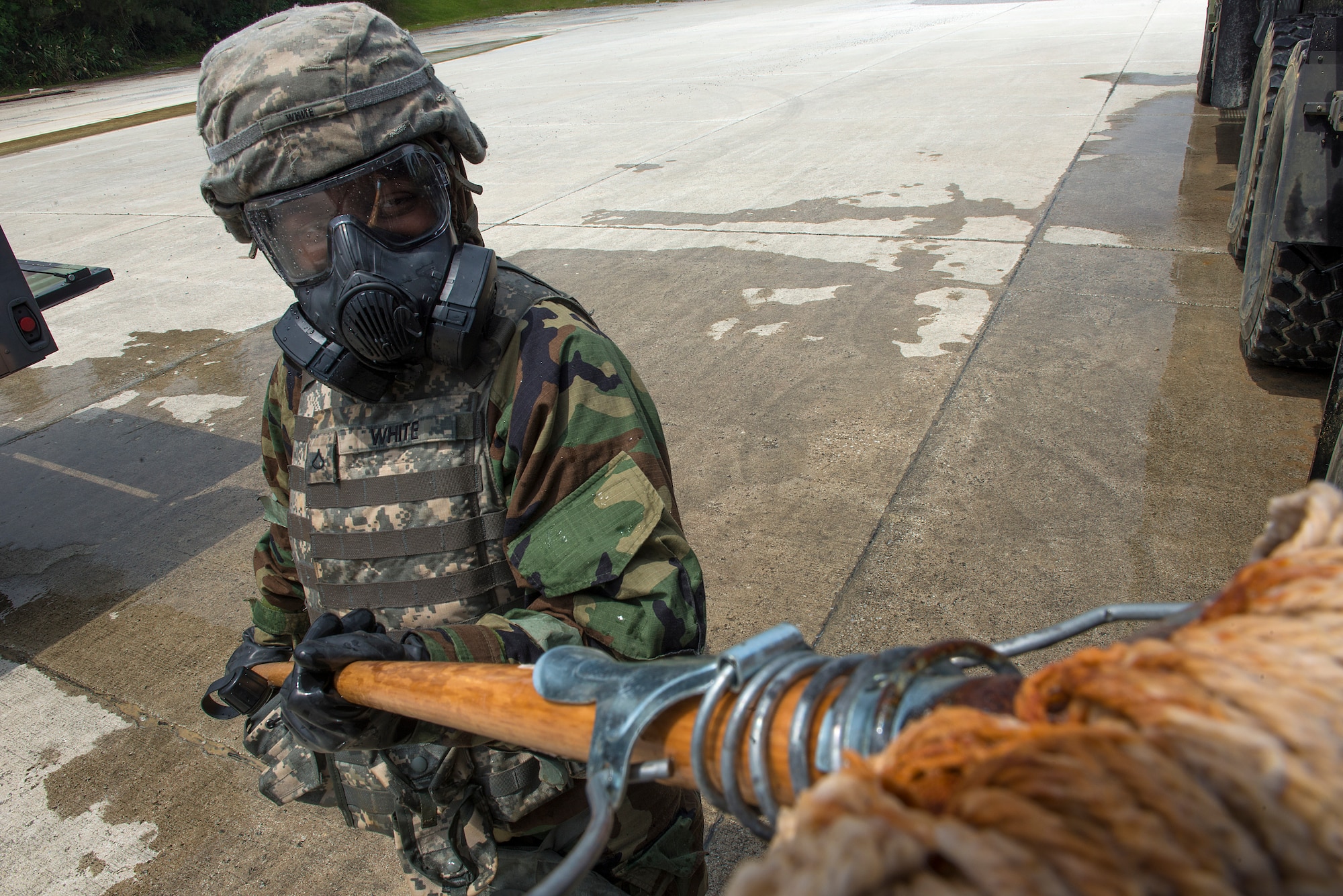 A U.S. Army Soldier from the 1-1 Air Defense Artillery Headquarters and Headquarters Battalion wears mission-oriented protective posture while she scrubs a military vehicle during a joint decontamination exercise May 12, 2016, at Kadena Air Base, Japan. This was the first time in recent history that the 1-1 ADA partnered with Air Force chemical, biological, radiological and nuclear decontamination experts for joint training in this capacity. (U.S. Air Force photo by Staff Sgt. Maeson L. Elleman)