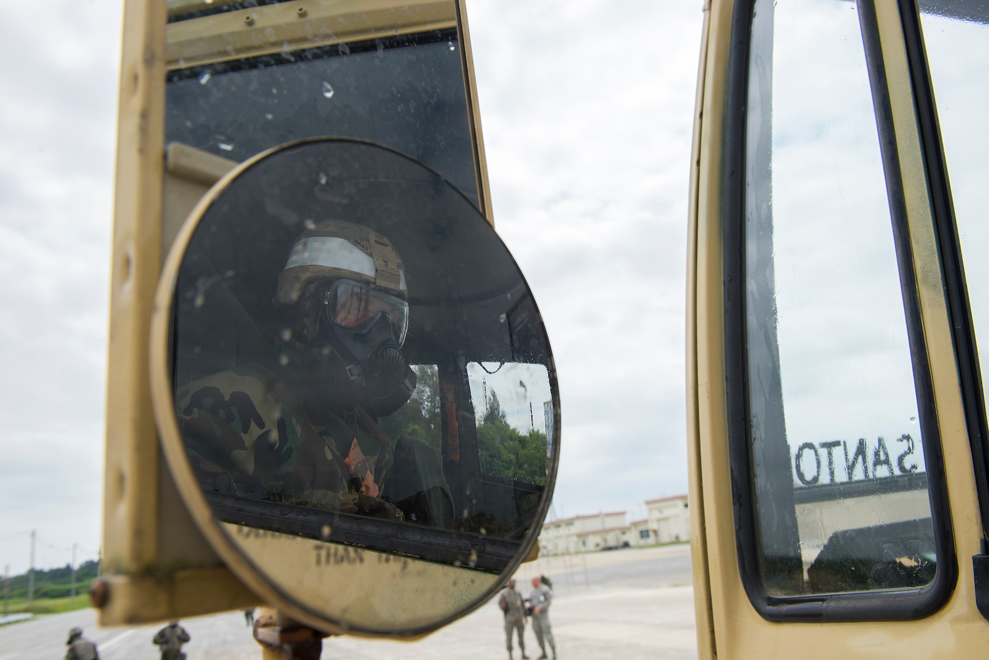 A U.S. Army Soldier from the 1-1 Air Defense Artillery Headquarters and Headquarters Battalion wearing mission-oriented protective posture gear looks out from his vehicle during a joint decontamination exercise May 12, 2016, at Kadena Air Base, Japan. Practicing decontamination techniques with the Air Force gave participating Soldiers and Airmen alike the opportunity to see each other work and better prepare one another for potential real-world operations in the future. (U.S. Air Force photo by Staff Sgt. Maeson L. Elleman)