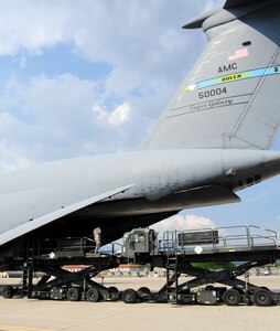 Members of the 612th Air Base Squadron maneuver a K Loader close to a C-5M Super Galaxy from Dover Air Force Base, Del., at Soto Cano Air Base, Honduras, May 13, 2016. The Denton Program, created to allow private U.S. citizens and organizations to use space available on U.S. military cargo planes, helps to transport humanitarian goods to countries in need. The Denton Program at Soto Cano AB is overseen by the base's joint partners in JTF-Bravo’s Civil Military Operations Directorate with support from the 612th Air Base Squadron’s Air Terminal Operations Center. (U.S. Army photo by Martin Chahin)
