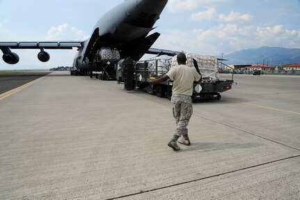A member of the 612th Air Base Squadron marshals the driver of a K Loader at Soto Cano Air Base, Honduras, May 13, 2016. In 2015, over 142,000 pounds of cargo valued at $590,000 passed through Soto Cano AB via the Denton Program. (U.S. Army photo by Martin Chahin)