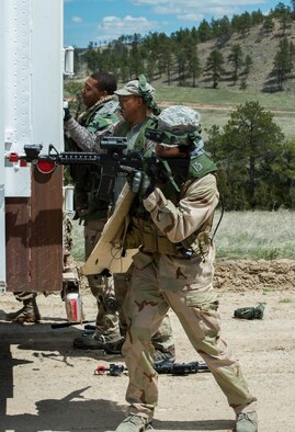 Airmen assigned to the 621st Contingency Response Wing attempt to break into the PT Van during a missile convoy attack scenario for exercise Road Warrior at Camp Guernsey, Wyo., May 3, 2016. The 621st CRW Airmen played the opposing force for the Global Strike Command exercise, which evaluates tactics, techniques, and procedures used to secure nuclear–capable weapons and critical intercontinental ballistic missile components during convoy operations. (U.S. Air Force photo by Staff Sgt. Robert Hicks/Released)