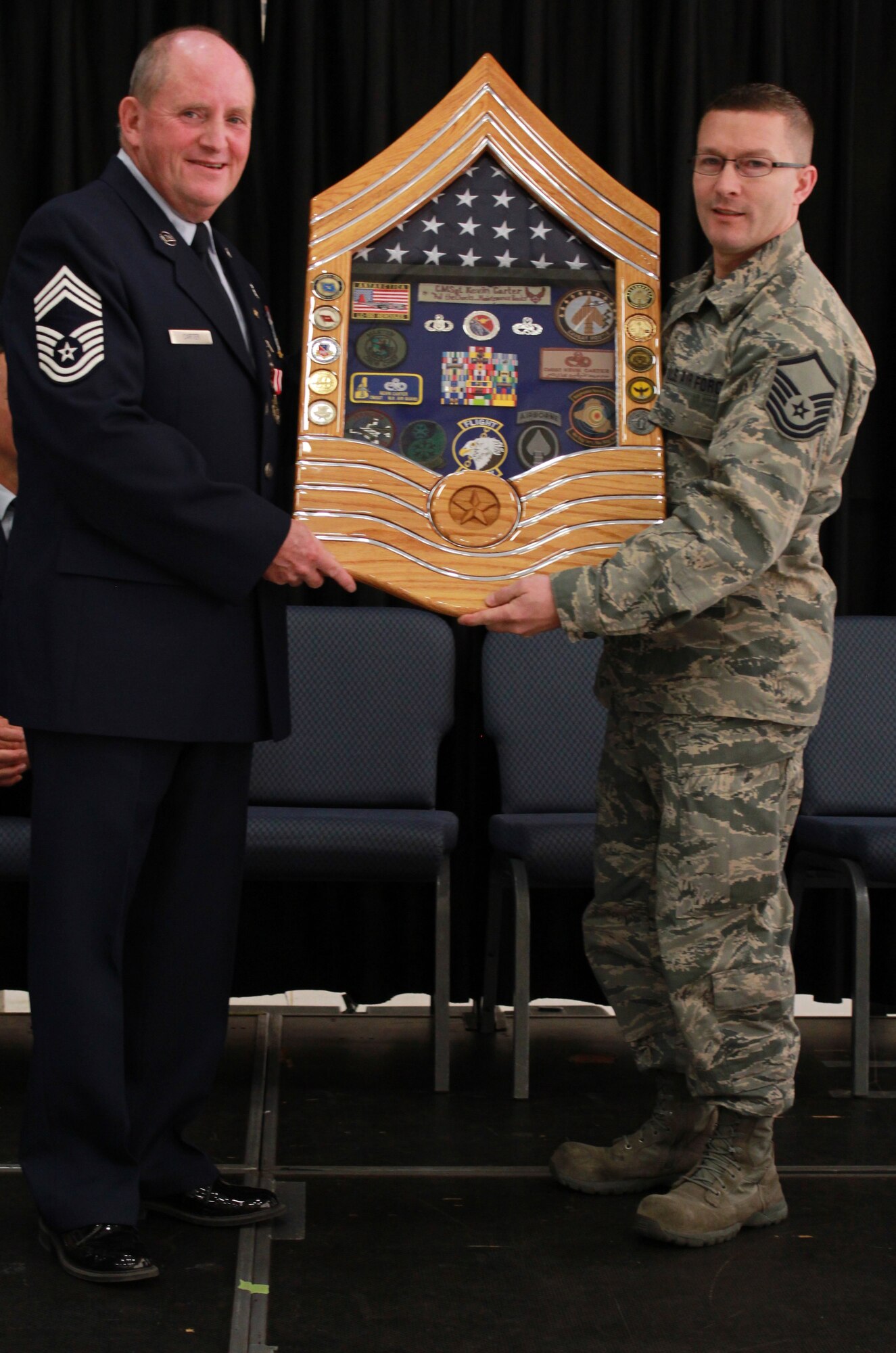 U.S. Air Force Chief Master Sgt. Kevin Carter accepts a shadow box during his retirement ceremony at Pease Air National Guard Base, N.H. May 14, 2016. Carter retired from the 157th Air Refueling Wing after 39 years of military service. (U.S. Air National Guard photo by Staff Sgt. Kayla Rorick)
