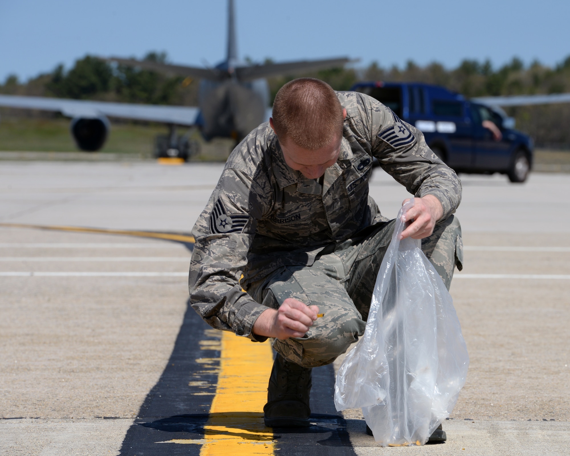 U.S. Air Force Tech. Sgt. Andrew Morrison, 157th Maintenance Group aircraft structural maintenance specialist, picks up a piece of debris during a quarterly foreign object damage (FOD) walk, Pease Air National Guard Base, N.H., May 11, 2016. FOD debris has the potential to damage aircraft during critical phases of flight, which can lead to catastrophic loss of life and airframe, and at the very least increased maintenance and operating costs.  (U.S. Air National Guard photo by Staff Sgt. Curtis J. Lenz)