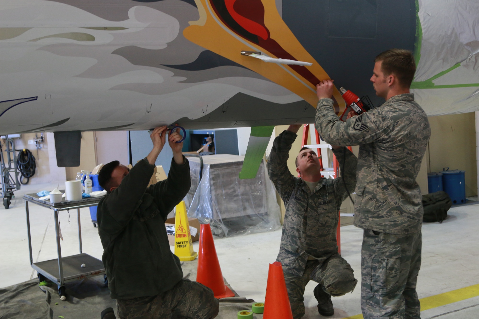Airmen from the 173rd Maintenance Structural shop touch up the nose stencil of the screaming eagle on the ORANG 75th Anniversary F-15 Eagle. (U.S. Air National Guard photo by Master Sgt. Jennifer Shirar)