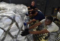 Members of the 612th Air Base Squadron move a pallet towards a K Loader while aboard a C-5M Super Galaxy from Dover Air Force Base, Del., at Soto Cano Air Base, Honduras, May 13, 2016. Through the Denton Program, the C-5 delivered approximately 85,000 pounds of rice and beans which is to be distributed to people in the Yoro Department of Honduras by a local non-governmental organization. (U.S. Air Force photo by Staff Sgt. Siuta B. Ika)