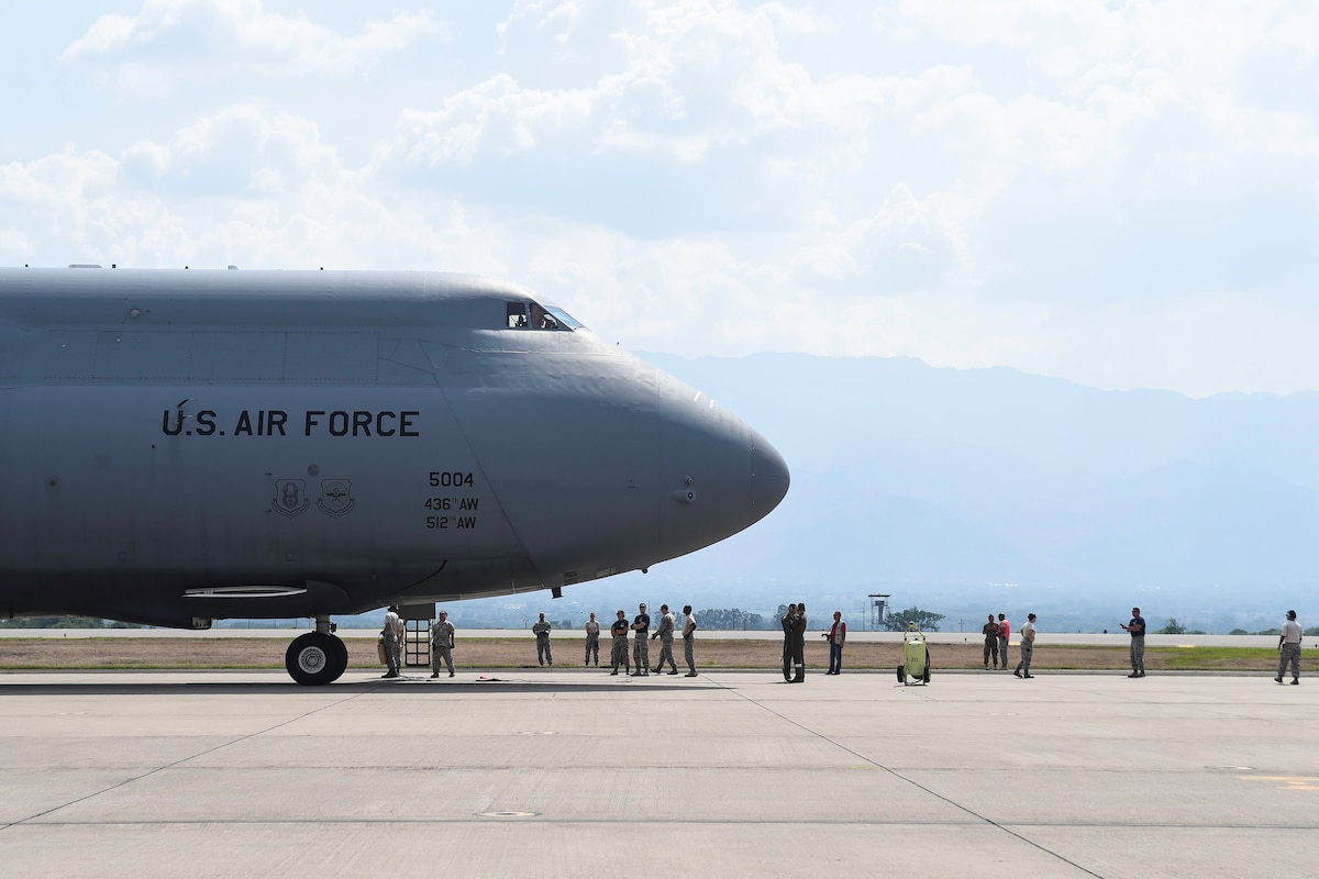 Members of the 612th Air Base Squadron prepare to board a C-5M Super Galaxy from Dover Air Force Base, Del., after its arrival to Soto Cano Air Base, Honduras, May 13, 2016. Through the Denton Program, the C-5 delivered approximately 85,000 pounds of rice and beans which is to be distributed to people in the Yoro Department of Honduras by a local non-governmental organization. (U.S. Air Force photo by Staff Sgt. Siuta B. Ika)
