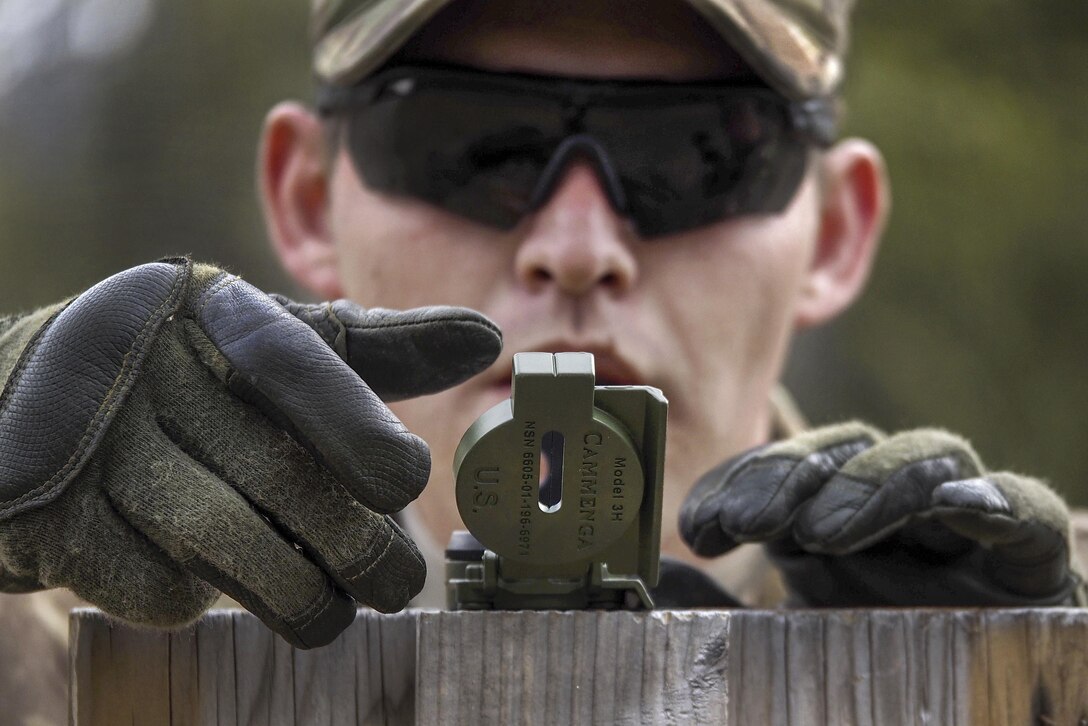 A soldier tests the accuracy of a compass before participating in the land navigation portion of the Best Warrior Competition at Joint Base Elmendorf-Richardson, Alaska, May 3, 2016. Air Force photo by Justin Connaher