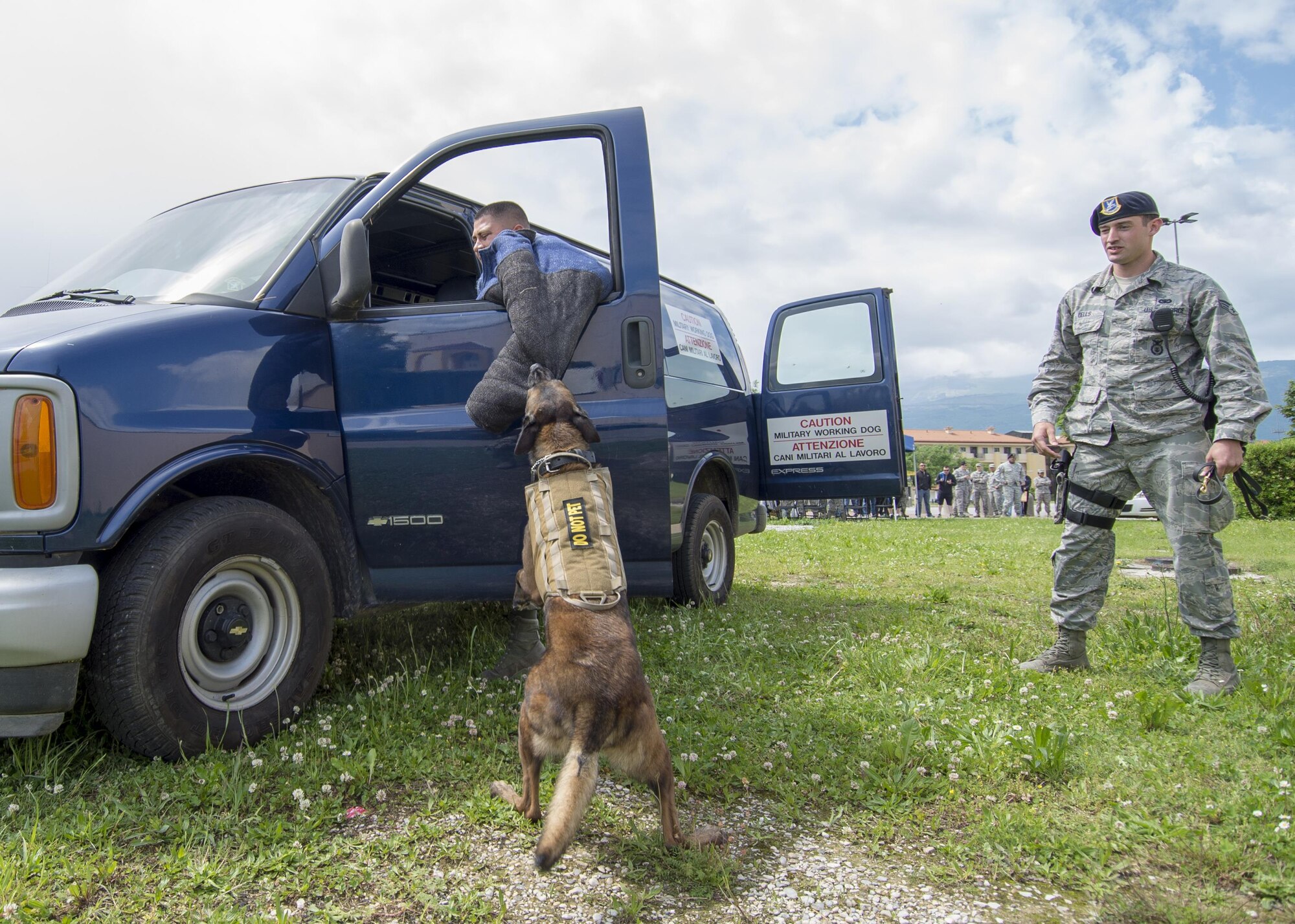 Senior Airman Jonathan Eells, 31st Security Force Squadron military working dog handler, and Rocky, 31st SFS MWD, demonstrate the apprehension of a suspect during a MWD demo during National Police Week May 16, 2016, at Aviano Air Base, Italy. The demo also served as a training opportunity for Rocky, it provided distractions, such as sounds and scents, which helps train MWD to maintain focus. (U.S. Air Force photo by Airman 1st Class Cory W. Bush/Released)