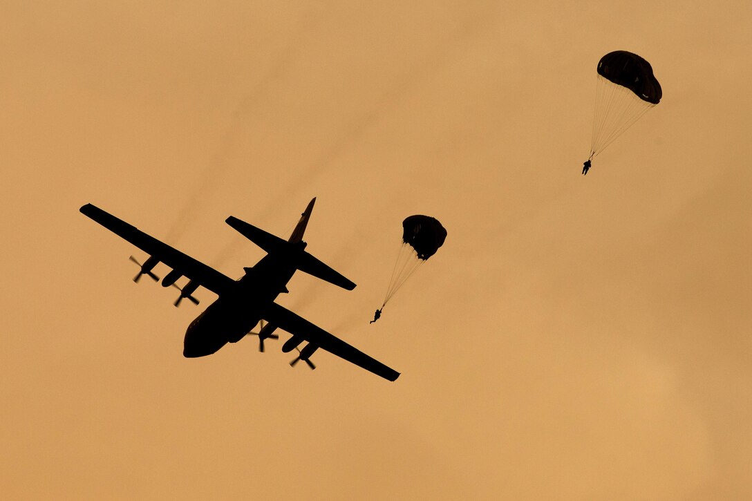 Marines jump from an Air Force C-130 Hercules aircraft over the drop zone during Jump Week at Yokota Air Base, Japan, May 11, 2016. The Marines are assigned to the 3rd Reconnaissance Battalion, 3rd Marine Division, 3rd Marine Expeditionary Force. Air Force photo by Yasuo Osakabe