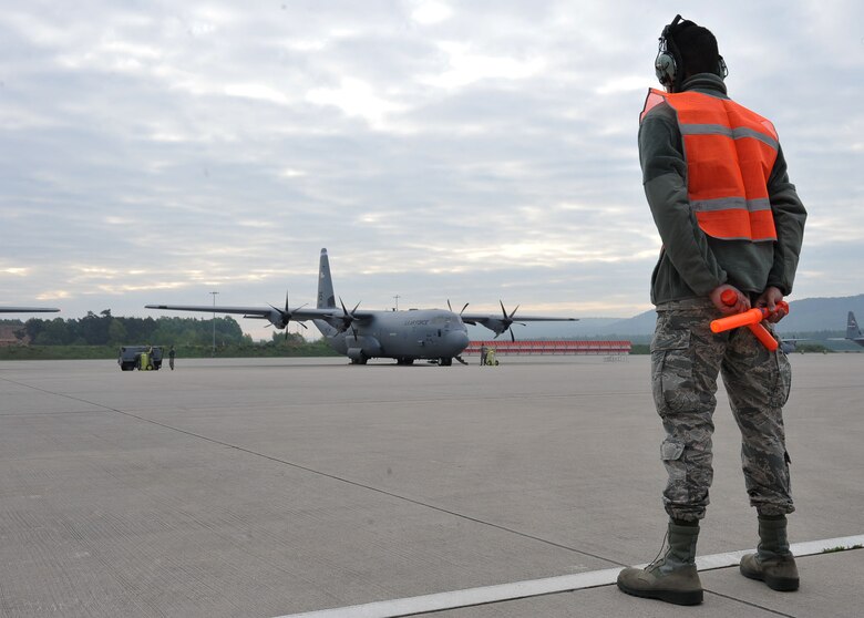 Airman 1st Class Zachary Jackson, 86th Maintenance Squadron crew chief apprentice, waits to marshal a C-130J Super Hercules May 17, 2016 at Ramstein Air Base, Germany. Jackson is attending phase two of the crew chief training course designed for newly arrived maintenance personnel. (U.S. Air Force photo/Staff Sgt. Leslie Keopka)