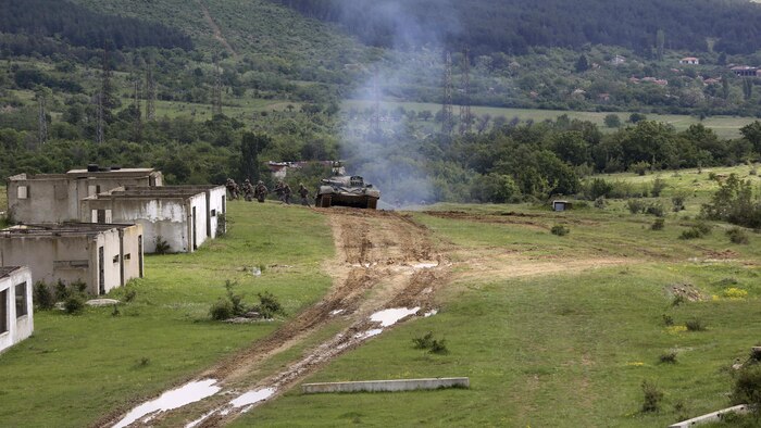 U.S. Marines with Bravo Company, Special Purpose Marine Air-Ground Task Force Crisis Response-Africa, rush to the first building while the Bulgarian T-72 tank to provides cover for the assault on Military Operations on Urban Terrain Town during Platinum Lion 16-3 at the Novo Selo Training Area, Bulgaria, May 10, 2016. Hundreds of troops from five NATO countries came together to train with mechanized assets and demonstrate the ability to work seamlessly as one force. 