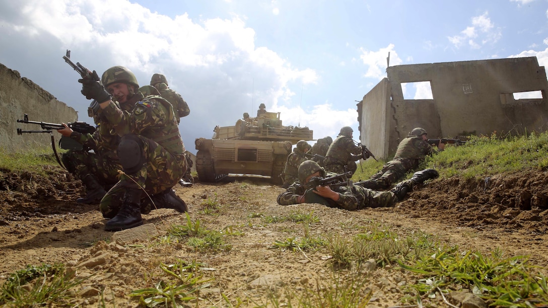 Romanian soldiers with the 634th Infantry Battalion post rear security as a U.S. Marine Corps M1A1 Abrams tank clears the path ahead for the assault on Military Operations on Urban Terrain Town during Platinum Lion 16-3 at the Novo Selo Training Area, Bulgaria, May 10, 2016. Hundreds of troops from five NATO countries came together to train with mechanized assets and demonstrate the ability to work seamlessly as one force.