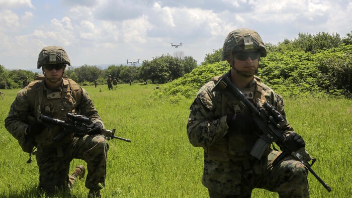 U.S. Navy Petty Officer 3rd Class Thomas C. Guess, a corpsman with Bravo Company, Special Purpose Marine Air-Ground Task Force Crisis Response-Africa, left, maintains a low-profile alongside U.S. Marine Corps Staff Sgt. Jeremy J. Jenkins, a platoon sergeant with Bravo Company, Special Purpose Marine Air-Ground Task Force Crisis Response-Africa, right, as MV-22 Ospreys take off during Platinum Lion 16-3 at the Novo Selo Training Area, Bulgaria, May 14, 2016. During the exercise, Allies from the United States and four partner nations conducted platoon-level mechanized tactics in order to develop proficiency in fire and maneuver. 