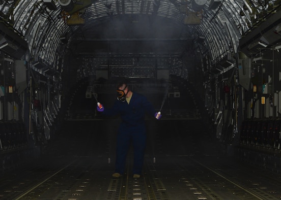 Staff Sgt. Daniel Fink, a 436th Civil Engineer Squadron Pest Management supervisor, places aerosol fog canisters of Callington 1-Shot inside of a C-17 Globemaster III to treat for mosquitos that are potentially carrying the Zika virus May 11, 2016, at Dover Air Force Base, Del. Once the aerosol cans are fully dispensed, the aircraft is sealed for 15-20 minutes so the treatment can take effect. (U.S. Air Force photo/Senior Airman William Johnson)