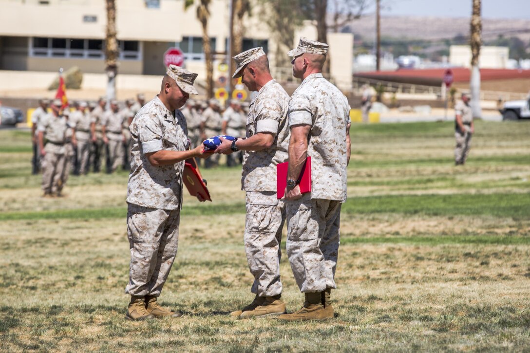 Maj. Gen. Lewis A. Craparotta, Combat Center Commanding General, presents the nation’s colors to Sgt. Maj. Karl Villalino, former Combat Center Sergeant Major, during a relief and appointment ceremony at Lance Cpl. Torrey L. Gray Field May 10, 2016. During the ceremony, Villalino relinquished his post as Combat Center Sergeant Major to Sgt. Maj. Michael J. Hendges and retired after 30 years of honorable service. (Official Marine Corps photo by Lance Cpl. Levi Schultz/Released)