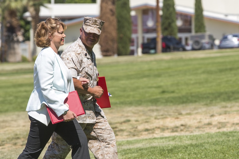 Sgt. Maj. Karl Villalino, former Combat Center Sergeant Major, escorts his wife, Deanna Villalino, during a relief and appointment ceremony at Lance Cpl. Torrey L. Gray Field May 10, 2016. Villalino relinquished his post as Combat Center Sergeant Major to Sgt. Maj. Michael J. Hendges and retired after 30 years of honorable service. (Official Marine Corps photo by Lance Cpl. Levi Schultz/Released)