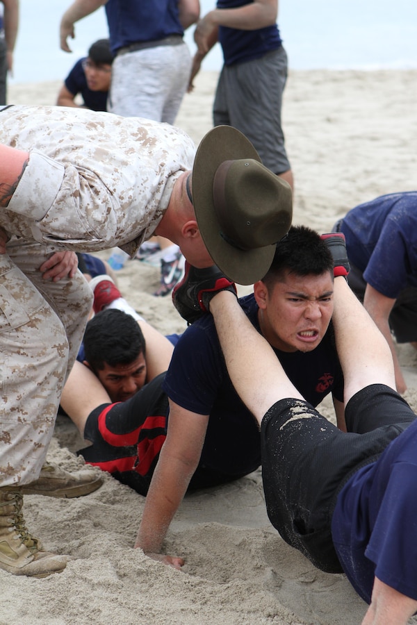 Senior Drill Instructor Staff Sgt. Corey A. Grey, commands a poolee from Recruiting Station Los Angeles to conduct squad push-ups during Recruiting Station Los Angeles’ Annual Pool Function at Point Mugu Beach, May 14, 2016. Los Angeles Marines and more than 600 of their poolees participated in the 2016 annual pool function. After nearly six hours of competing in pull-ups, crunches, fitness relays, tug-of-war, and many other activities, RSS Lancaster came out on top as the RSLA pool function champions. (U.S. Marine Corps photo by Staff Sgt. Alicia R. Leaders/Released)