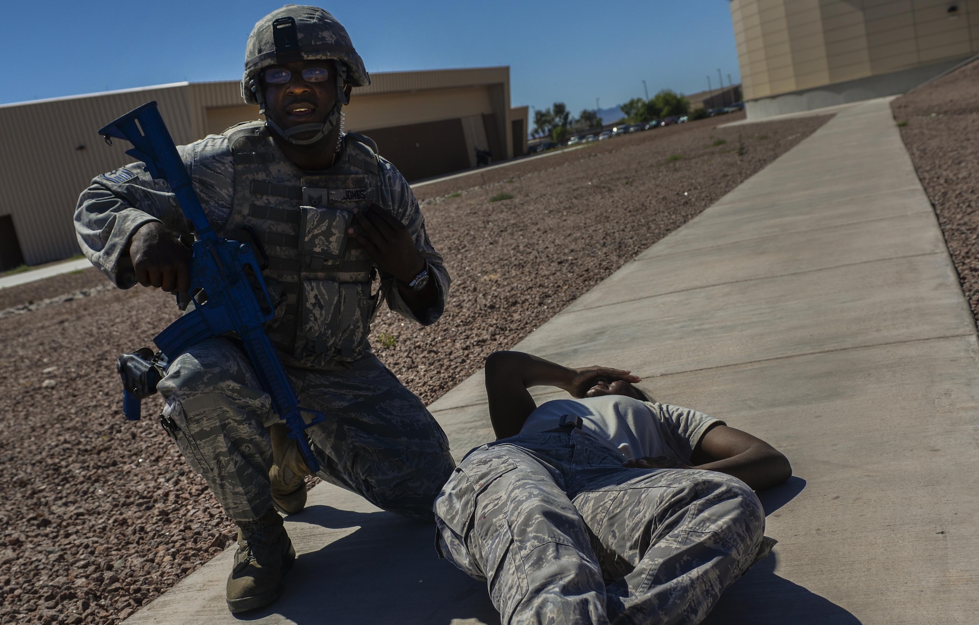A 99th Security Forces Squadron Airman uses his radio to communicate with other Airmen on the scene during a simulated active shooter attack during a base exercise at Nellis Air Force Base, Nev., May 12, 2016. The exercise scenario was complex and had many moving part in order to present unique challenges to the units that participated. (U.S. Air Force photo by Airman 1st Class Kevin Tanenbaum)