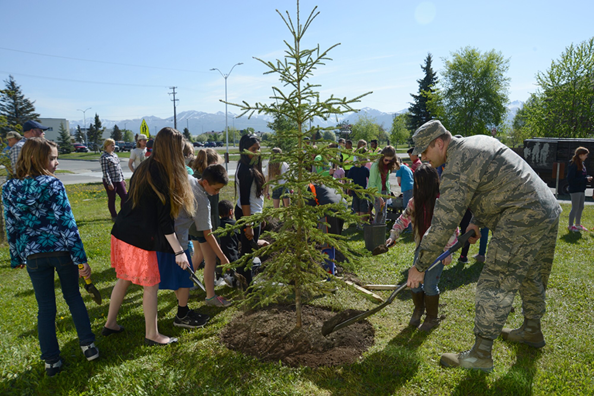 Air Force Col. Scott Matthews, 673d Civil Engineer Group commander, helps Mount Spurr Elementary School fifth-grade students plant a white spruce tree for National Arbor Day at Joint Base Elmendorf-Richardson, May 16, 2016. The trees were provided through a grant from the Alaska Community Forest Council, the Alaska Division of Forestry and the U.S. Forest Service. (U.S. Air Force photo by Airman 1st Class Christopher R. Morales)