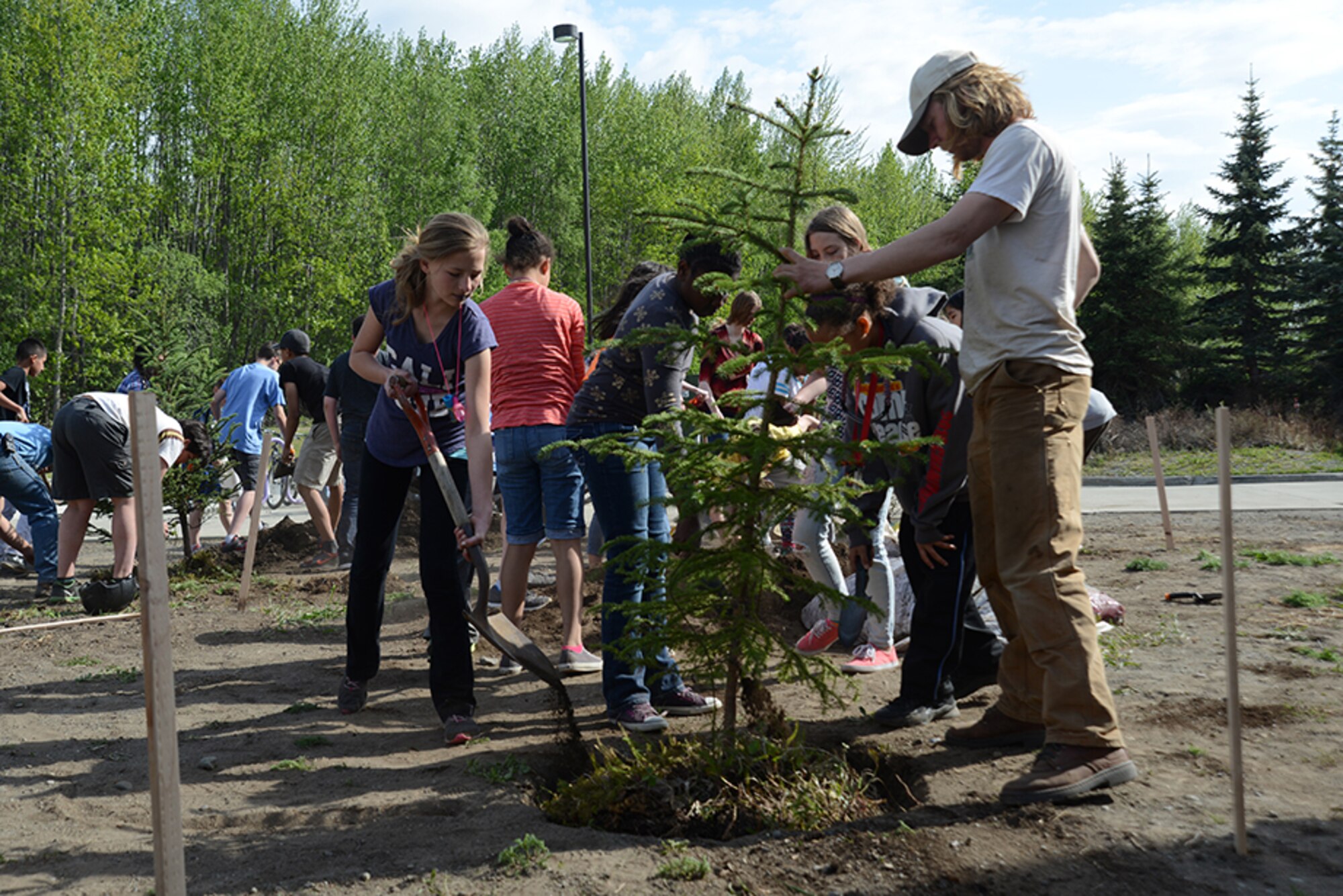 Members of the Torch and Keystone clubs plant two white spruce trees in front of the Two Rivers Youth Center for National Arbor Day at Joint Base Elmendorf-Richardson, May 16, 2016. The trees were provided through a grant from the Alaska Community Forest Council, the Alaska Division of Forestry and the U.S. Forest Service. (U.S. Air Force photo by Airman 1st Class Christopher R. Morales)