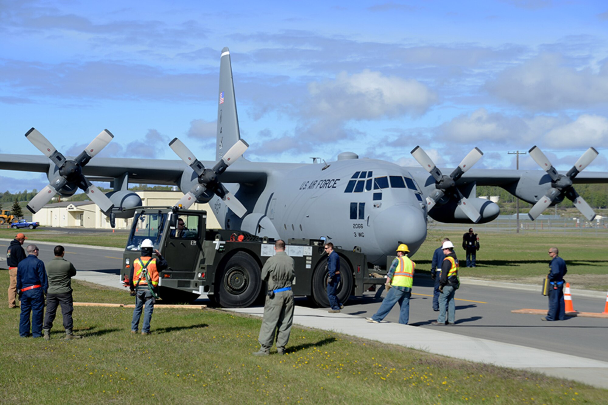 A C-130 Hercules prepares to cross the curb during the C-130 Hercules and F-102 Delta Dagger Heritage Park move at Joint Base Elmendorf-Richardson, Alaska, May 7, 2016. The F-102 weighs more than 19,000 pounds and the C-130 weighs more than 75,000 pounds so the 3rd MXS implemented a few safety precautions. (U.S. Air Force photo by Airman 1st Class Christopher R. Morales)