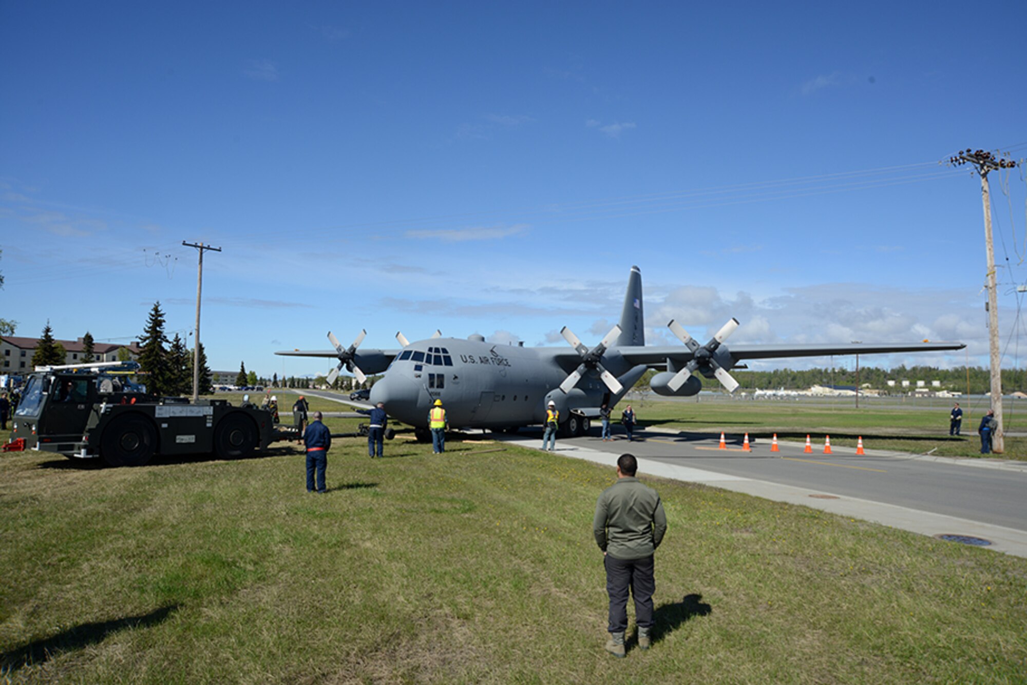 A C-130 Hercules squeezes between two telephone poles on its way to Heritage Park at Joint Base Elmendorf-Richardson, Alaska, May 7, 2016. Retired aircraft which have accomplished the Air Force mission are refurbished and put on display at Heritage Park. (U.S. Air Force photo by Airman 1st Class Christopher R. Morales)