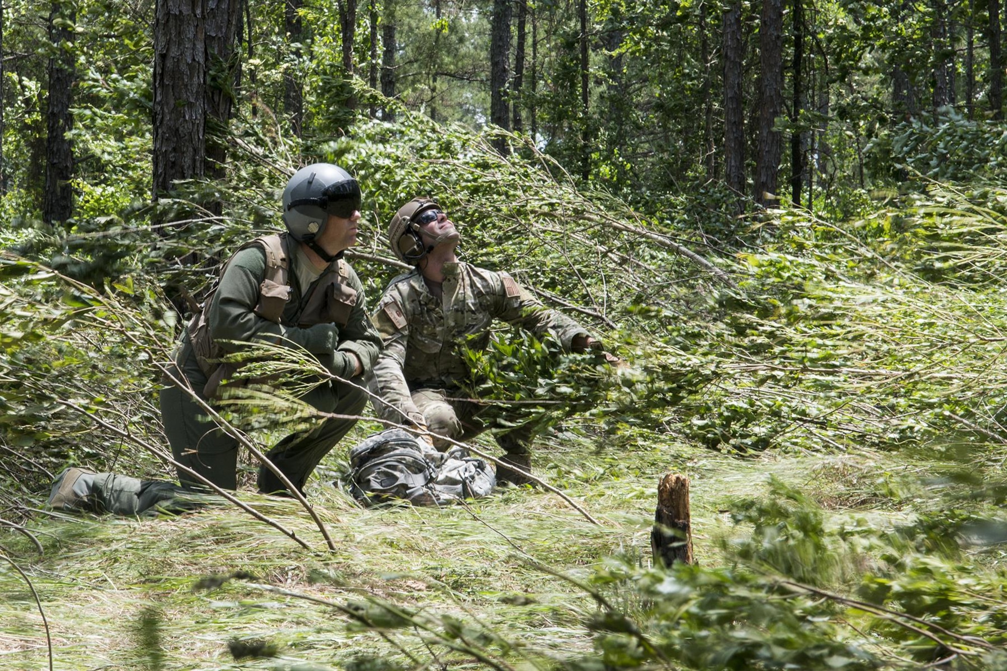 U.S. Air Force Lt. Col. Christopher Anderson, 307th Operations Support Squadron commander,  and Staff Sgt. Matthew Mete, 2nd Operations Support Squadron SERE instructor, brace themselves against the winds of a hovering helicopter during SERE training on May 14, 2016, Claiborne Gunnery and Bombing Range, La. SERE, which stands for Survival, Evasion, Resistance and Escape, is required training for all aircrew members and provides the knowledge and tools necessary to survive on their own in any environment and under any condition should they have to abandon their aircraft. (U.S. Air Force photo by Master Sgt. Greg Steele/Released)