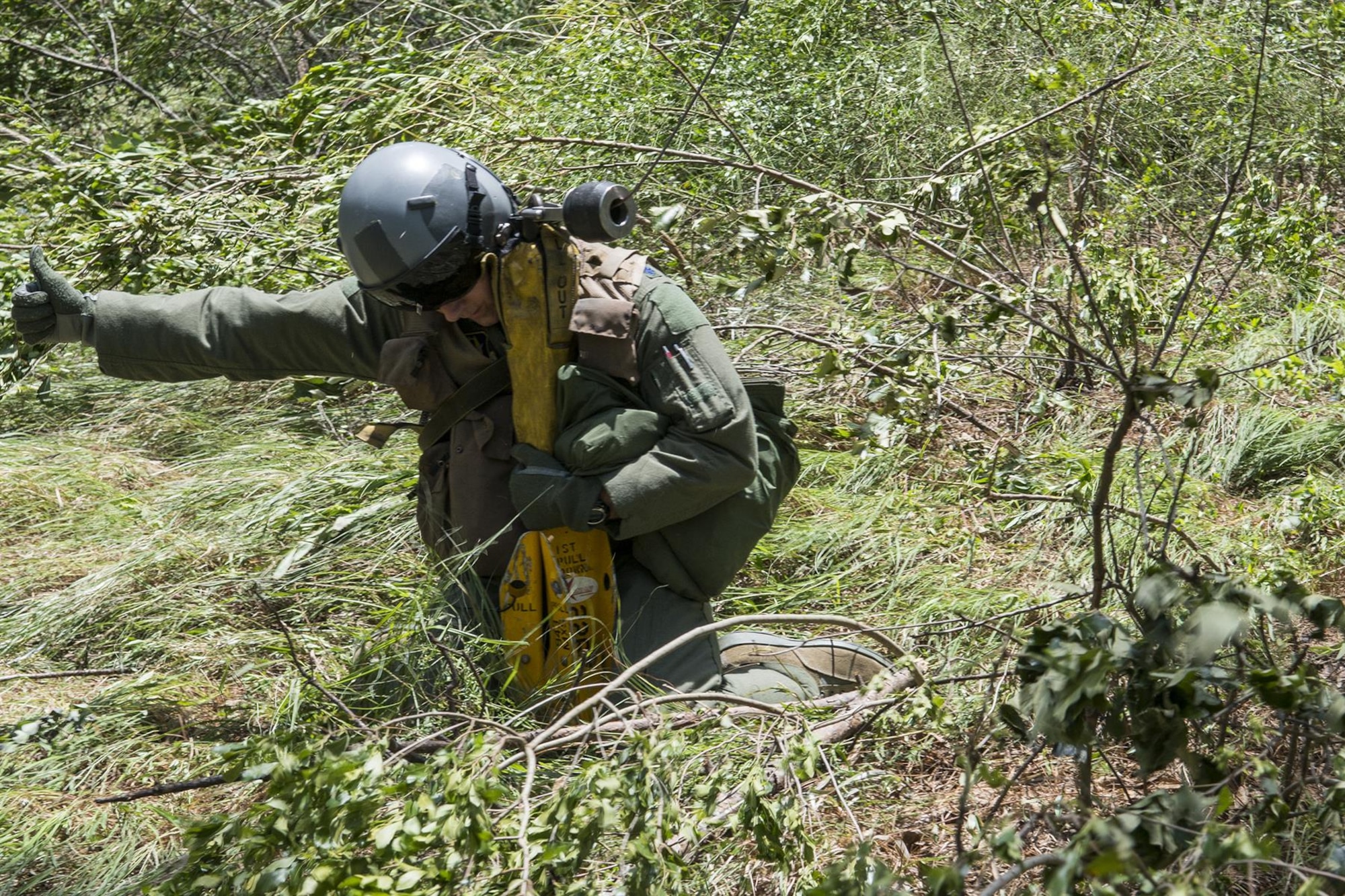 U.S. Air Force Lt. Col. Christopher Anderson, the commander of the 307th Operations Support Squadron, gives a thumbs to the helicopter crew as he grabs a tight hold onto the forest penetrator that will be used to hoist him up during SERE training on May 14, 2016, Claiborne Gunnery and Bombing Range, La. SERE, which stands for Survival, Evasion, Resistance and Escape, is required training for all aircrew members and provides the knowledge and tools necessary to survive on their own in any environment and under any condition should they have to abandon their aircraft. (U.S. Air Force photo by Master Sgt. Greg Steele/Released)