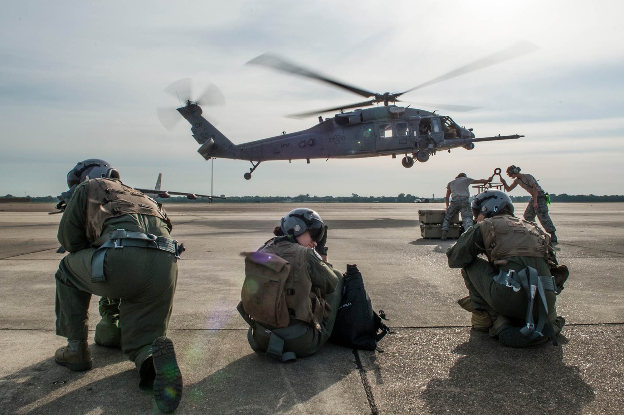 Three aircrew members of the 93rd Bomb Squadron await to board a 305th Rescue Squadron HH-60 Pave Hawk helicopter as part of Survival, Evasion, Resistance and Escape (SERE) training on May 14, 2015, Barksdale Air Force Base, La. SERE training gives aircrew the knowledge and tools necessary to survive on their own in any environment and under any condition should they have to abandon their aircraft. (U.S. Air Force photo by Master Sgt. Greg Steele/Released)