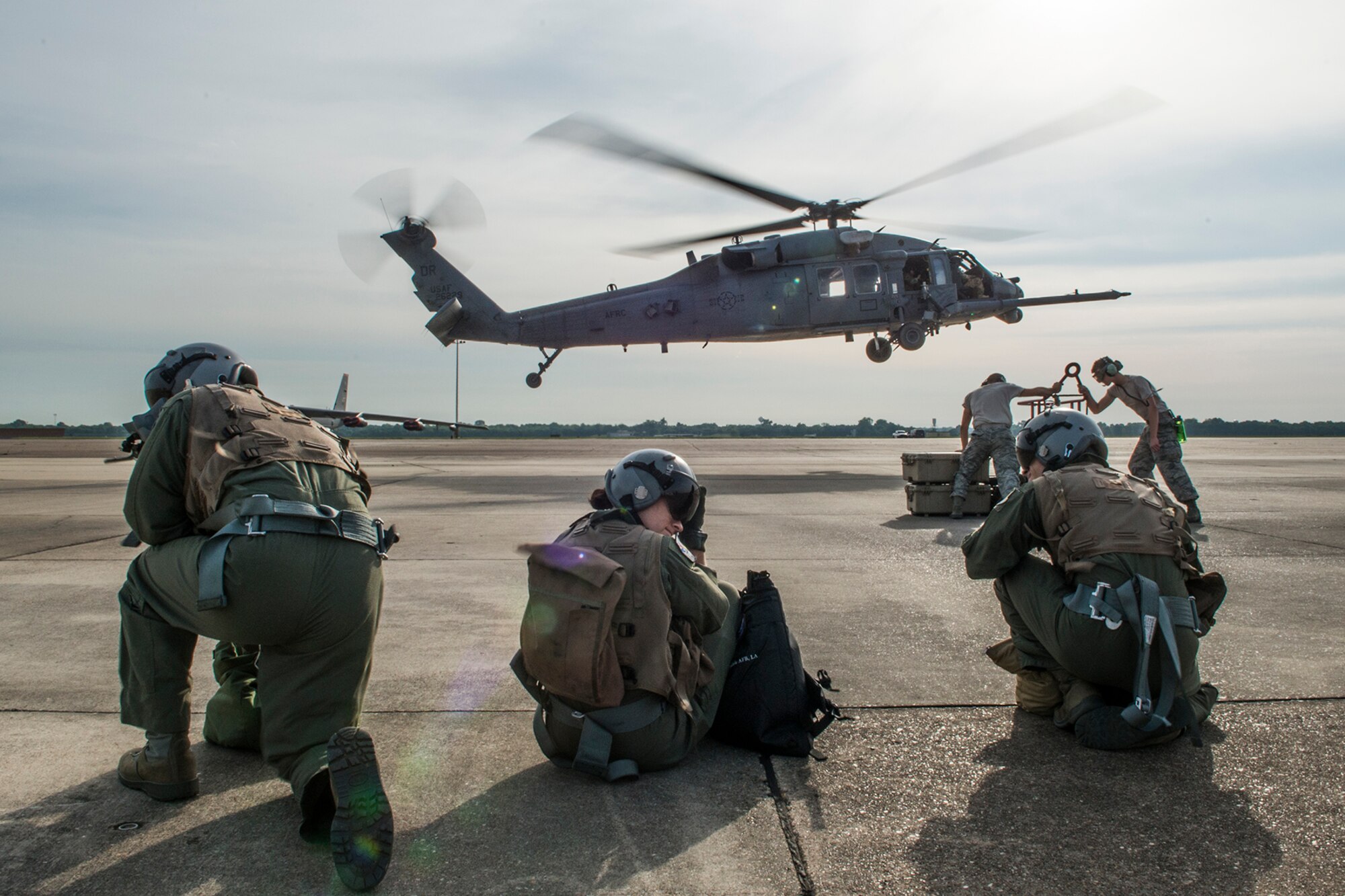 Three aircrew members of the 93rd Bomb Squadron await to board a 305th Rescue Squadron HH-60 Pave Hawk helicopter as part of Survival, Evasion, Resistance and Escape (SERE) training on May 14, 2015, Barksdale Air Force Base, La. SERE training gives aircrew the knowledge and tools necessary to survive on their own in any environment and under any condition should they have to abandon their aircraft. (U.S. Air Force photo by Master Sgt. Greg Steele/Released)