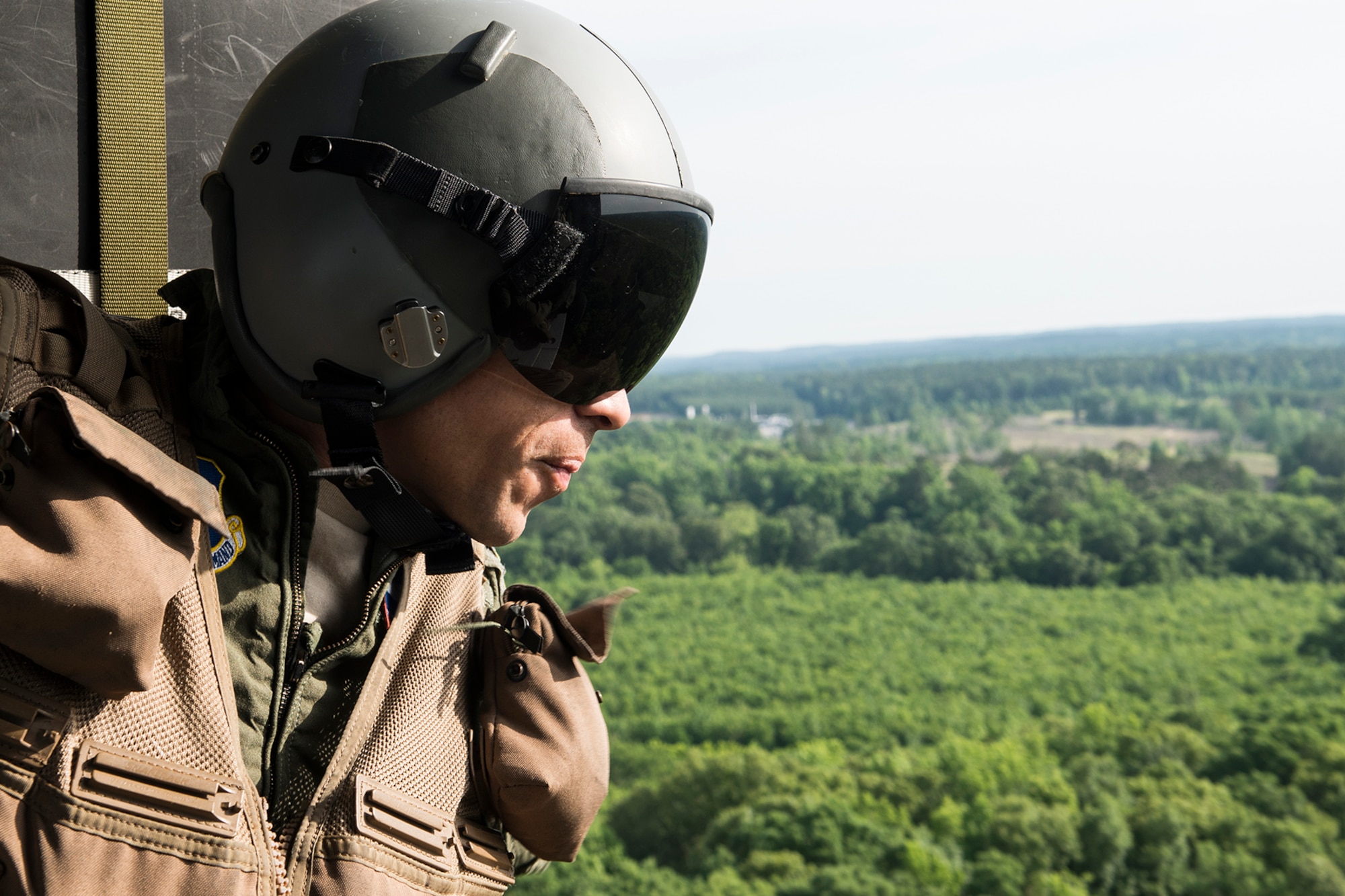 U.S. Air Force Lt. Col. Christopher Chandler, assigned to the 93rd Bomb Squadron, looks out the door of a 305th Rescue Squadron HH-60 Pave Hawk helicopter while on his way to Survival, Evasion, Resistance and Escape (SERE) training on May 14, 2015, Barksdale Air Force Base, La. SERE training gives aircrew the knowledge and tools necessary to survive on their own in any environment and under any condition should they have to abandon their aircraft. (U.S. Air Force photo by Master Sgt. Greg Steele/Released)