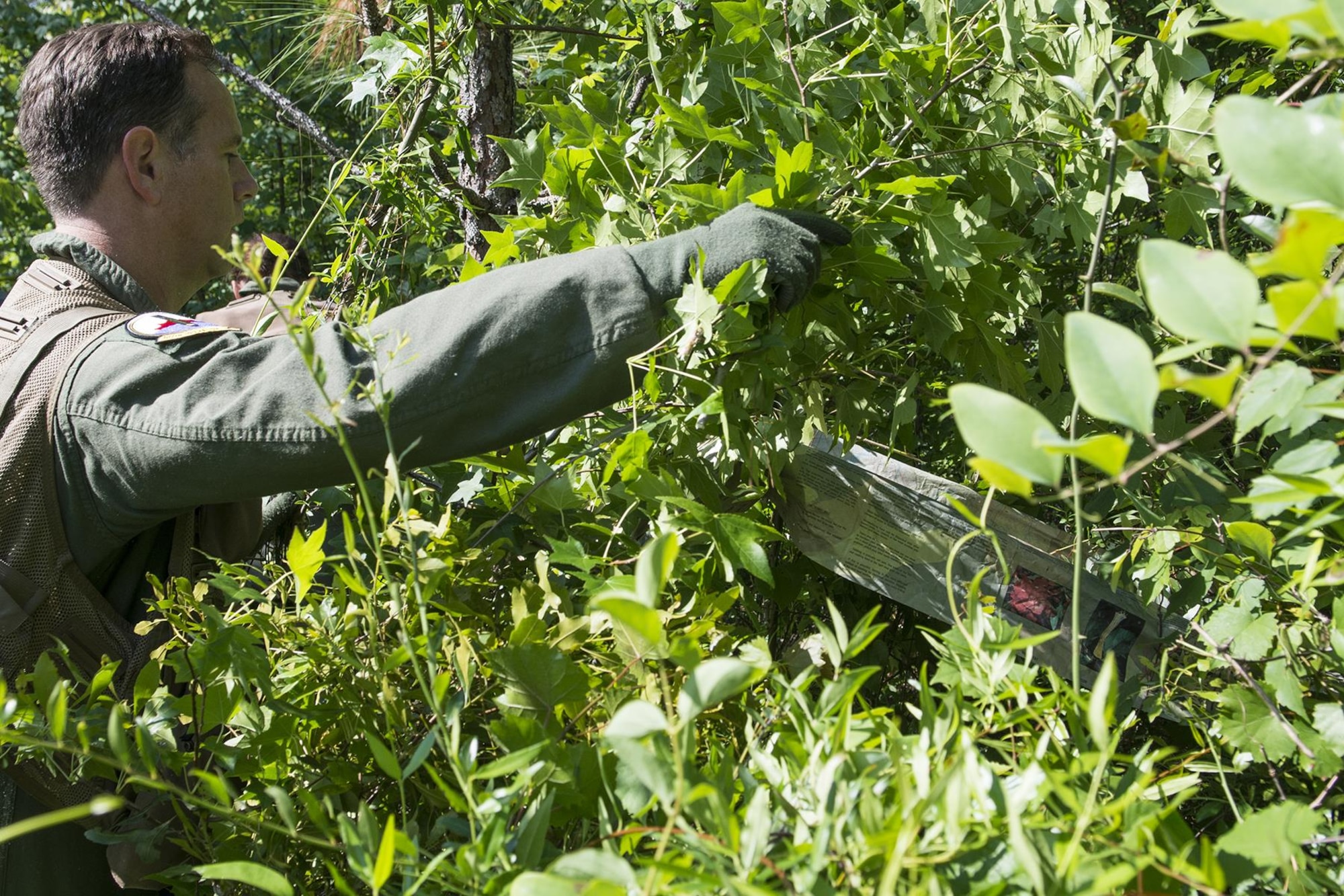 U.S. Air Force Lt. Col. Christopher Anderson, 307th Operations Support Squadron commander, camouflages his temporary shelter with foliage during SERE training on May 14, 2016, Claiborne Gunnery and Bombing Range, La. SERE, which stands for Survival, Evasion, Resistance and Escape, is required training for all aircrew members and provides the knowledge and tools necessary to survive on their own in any environment and under any condition should they have to abandon their aircraft. (U.S. Air Force photo by Master Sgt. Greg Steele/Released)