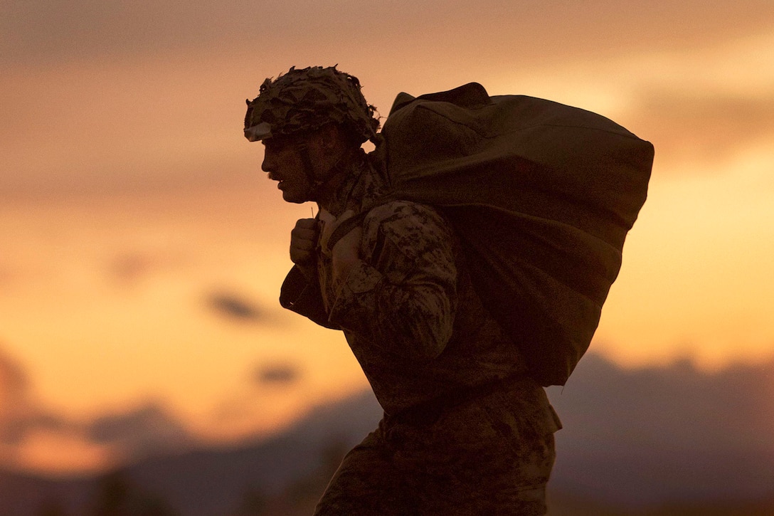 Marine Corps Cpl. Joshua Coulter carries a parachute from the drop zone to the rally point after jumping from an Air Force C-130 Hercules aircraft during Jump Week at Yokota Air Base, Japan, May 11, 2016. Coulter is assigned to the 3rd Reconnaissance Battalion, 3rd Marine Division, 3rd Marine Expeditionary Force. Air Force photo by Yasuo Osakabe
