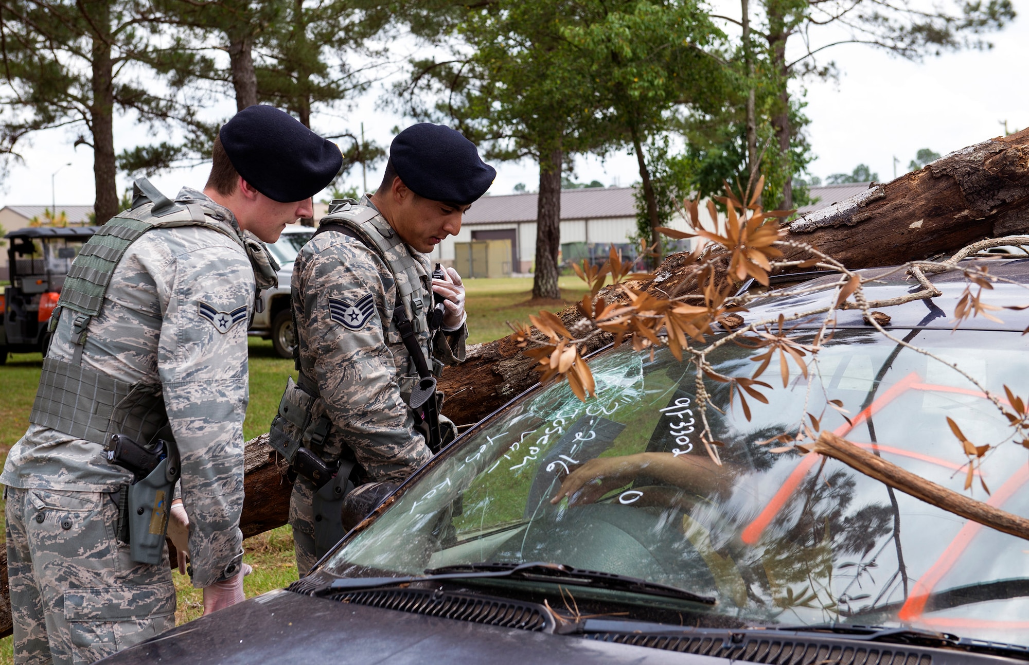 U.S. Air Force Airman 1st Class Taylor Cyr, left, and Staff Sgt. Issac Rhee, patrolmen from the 23d Security Forces Squadron, simulate relaying an injured victim’s health assessment to the 23d SFS Base Defense Operations Center during a hurricane exercise, May 17, 2016, at Moody Air Force Base, Ga. After reporting the health status, medical specialists and fire emergency technicians responded to the scene. (U.S. Air Force photo by Airman 1st Class Greg Nash/Released)
