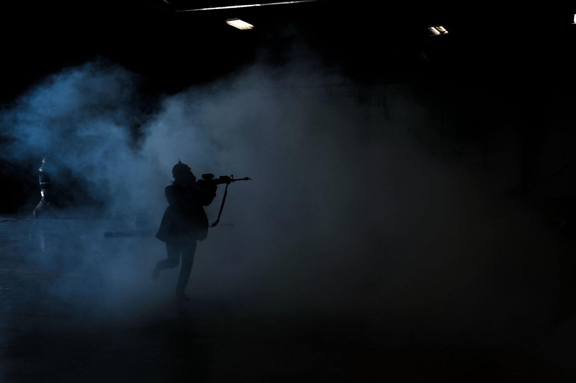 A simulated active shooter runs through building 220 on Nellis Air Force Base, Nev., during a base-wide exercise held May 12, 2016. Nellis AFB conducted a base wide exercise that involved multiple possible real-life scenarios to test the response capabilities of emergency personnel and the base. (U.S. Air Force photo by Senior Airman Rachel Loftis)