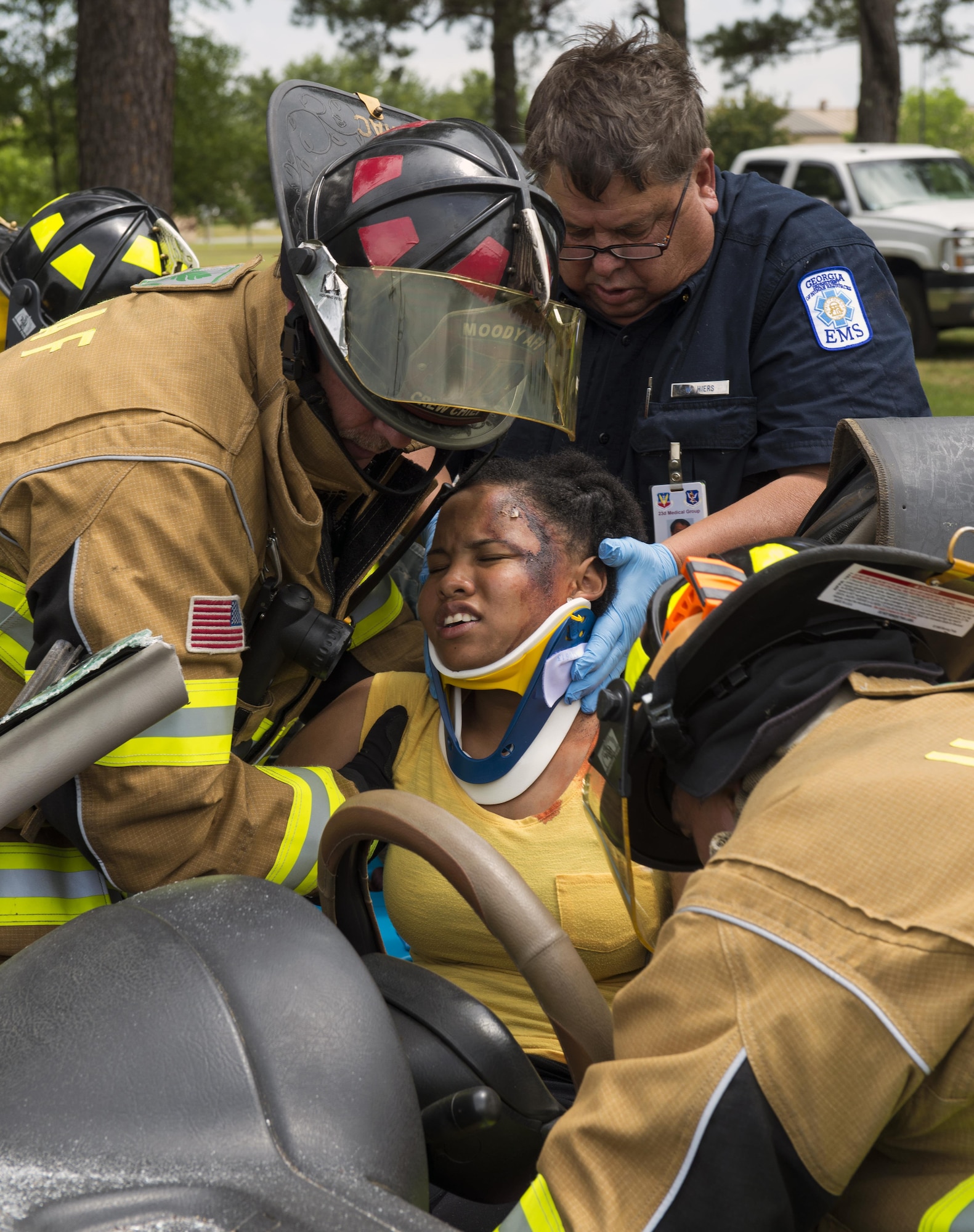 Firefighters from the 23d Civil Engineer Squadron simulate removing injured U.S. Air Force Senior Airman Gelisa Adams, 23d Medical Operations Squadron, after a car accident as a part of a hurricane exercise. First responders checked Adams for head trauma, arterial bleeding from the leg, burns, and head lacerations. (U.S. Air Force photo by Airman 1st Class Greg Nash/Released) 