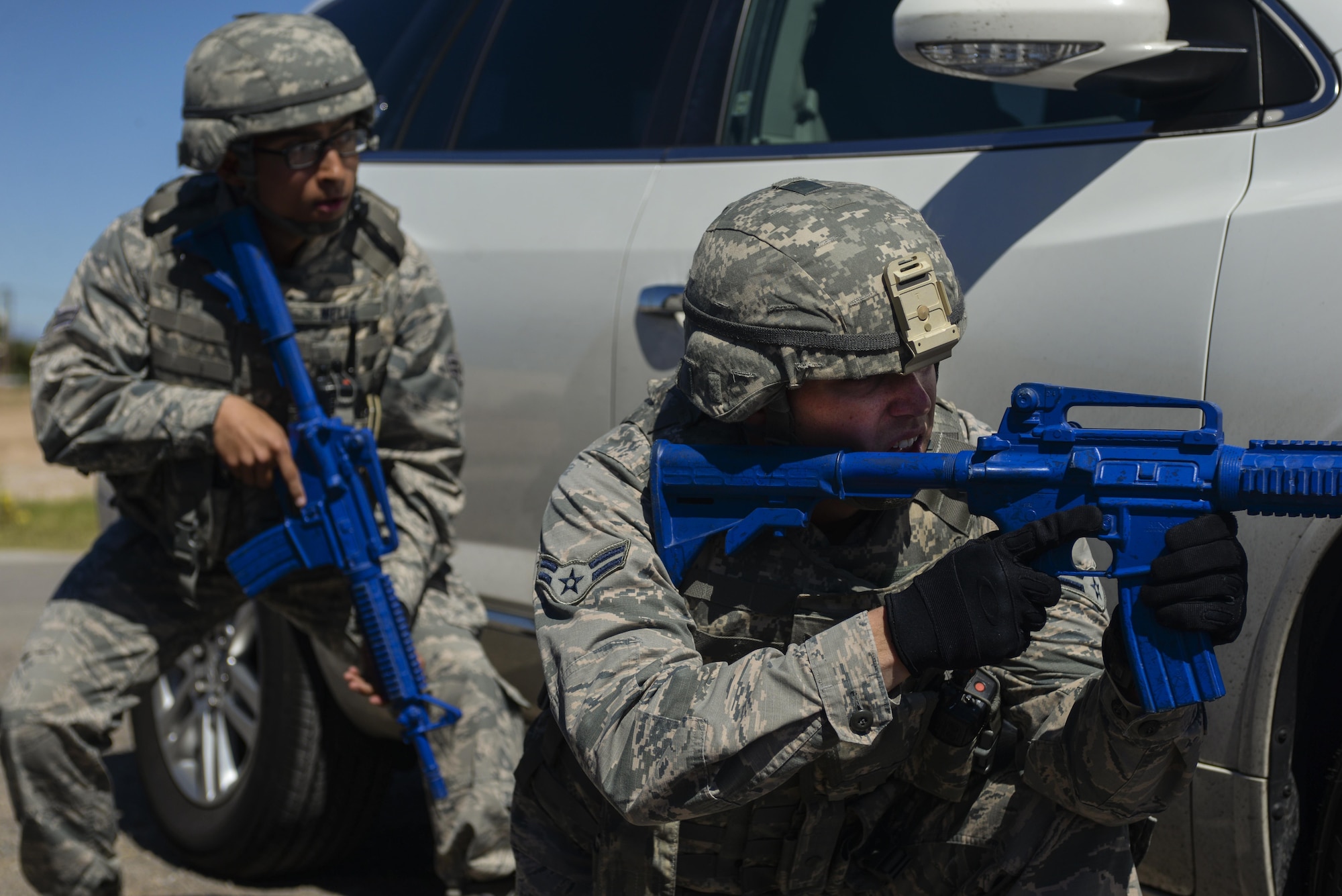 Airman 1st Class Robert Siegmann and Airman 1st Class Logan Welle, 99th Security Forces Squadron, prepare to rush a simulated active shooter during a base wide exercise at Nellis Air Force Base, Nev., May 12, 2016. The exercise scenario had two active shooters and a simulated explosive device. (U.S. Air Force photo by Airman 1st Class Kevin Tanenbaum)