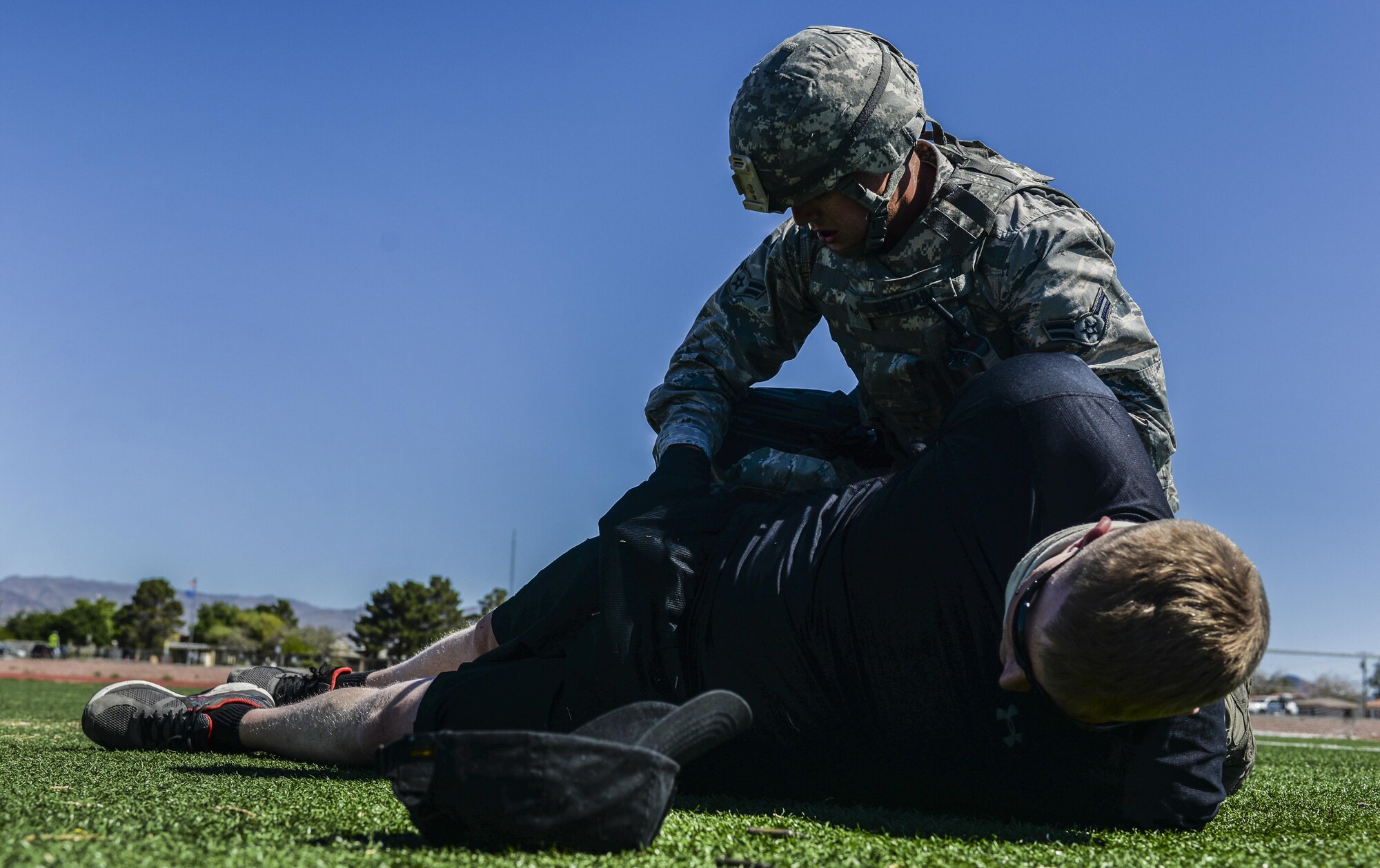 Airman 1st Class Mathew Brittain, 99th Security Forces Squadron, subdues and searches a simulated active shooter during a base wide exercise at Nellis Air Force Base, Nev., May 12, 2016. The 99th SFS was the first unit on the scene during the simulated scenario, followed by Explosive Ordnance Disposal, Emergency Management, the Fire Department and the Medical Group. (U.S. Air Force photo by Airman 1st Class Kevin Tanenbaum)