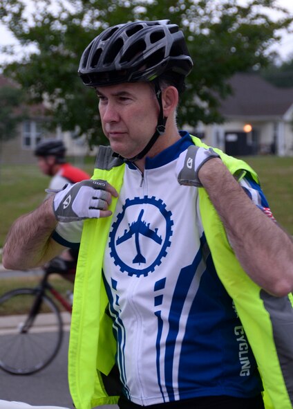 Russ Mathers, Air Force Global Strike Command executive director of communications, dons a safety vest before participating in a National Bike to Work Week bike ride at Barksdale Air Force Base, La., May 17, 2016. Members of the Barksdale Cycling Club provided a safe ride for participants by claring the bike trail of obstacles prior to the event. Every cyclist wore protective equipment and the bicycles were equipped with lights, so motor vehicles could easily spot the group. (U.S. Air Force photo/Senior Airman Amanda Morris)