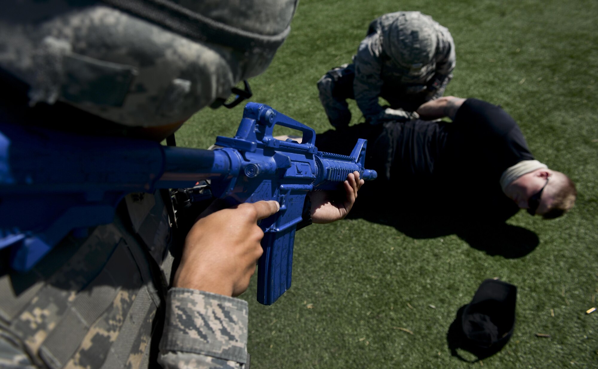 Airman 1st Class Logan Welle, 99th Security Forces Squadron, covers his wingman as he searches a simulated active shooter during a base exercise at Nellis Air Force Base, Nev., May 12, 2016. The exercise tested the readiness and procedures of the base with different sets of scenarios. (U.S. Air Force photo by Airman 1st Class Kevin Tanenbaum)
