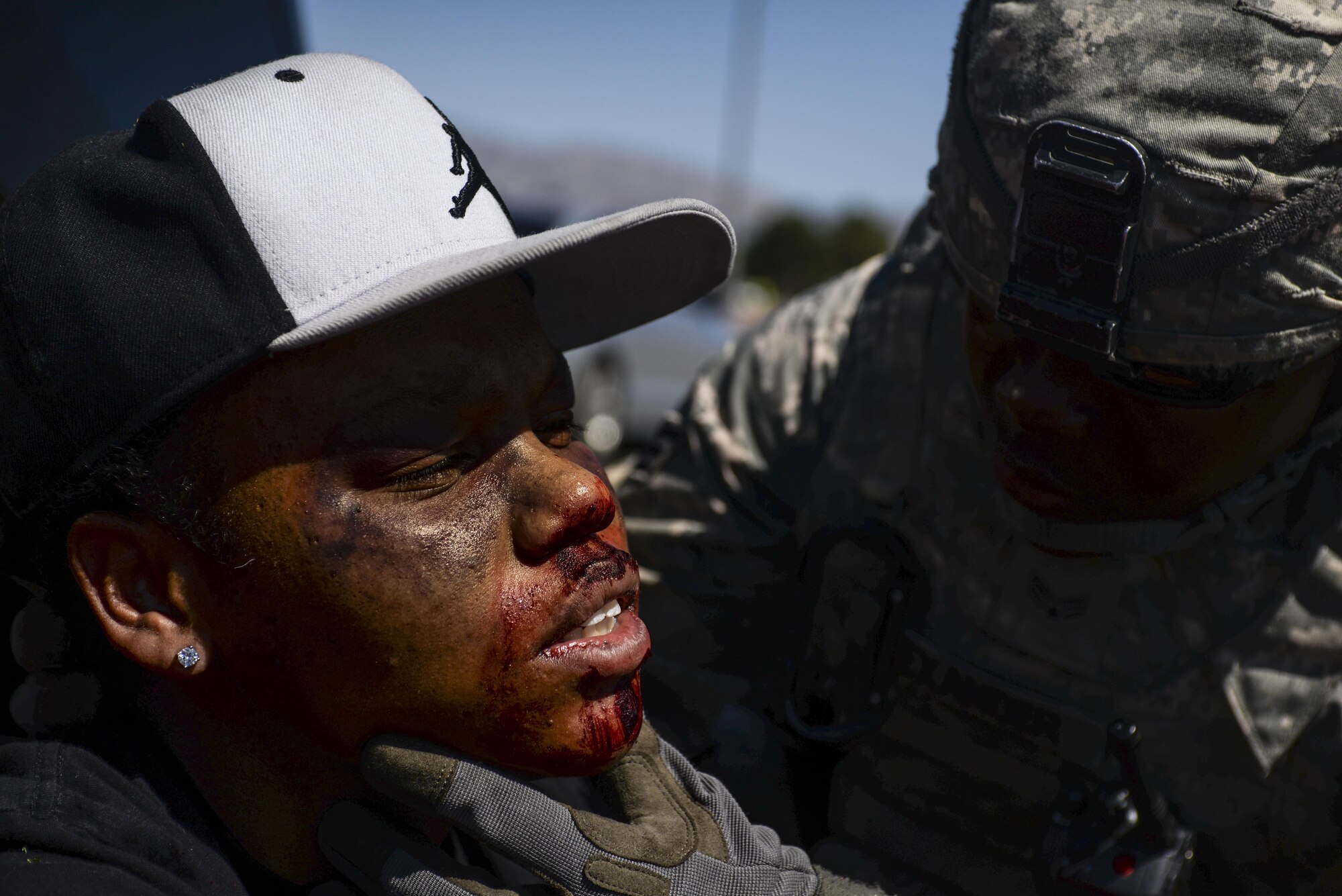 Senior Airman Terran Alexander, 99th Security Forces Squadron, checks wounds on a simulated victim during a base exercise at Nellis Air Force Base, Nev., May 12, 2016. Usually being the first ones on the scene of an emergency situation on base 99th SFS has a wide range of responsibilities, including handling the shooter and taking care of victims. (U.S. Air Force photo by Airman 1st Class Kevin Tanenbaum)