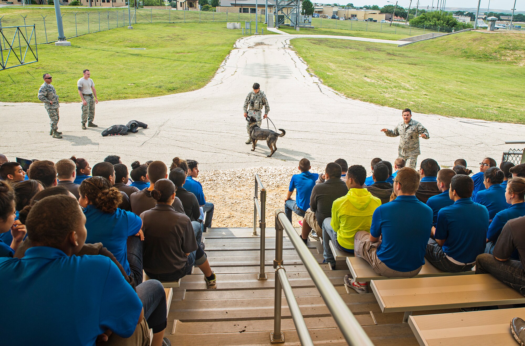 Staff Sgt. Nicholas Lewis, a 341st Training Squadron military working dog handler, narrates a MWD demonstration to Junior ROTC students from John Jay High School May 12, 2016 at Joint Base San Antonio-Lackland, Texas. The students toured the survival, engine, and structural engineering shops at the 433rd Airlift Wing and also saw a Military Working Dog demonstration at the 341st Training Squadron. (U.S. Air Force photo by Benjamin Faske) (released)