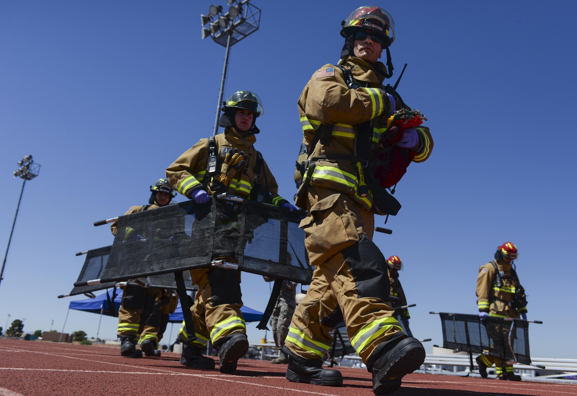 Airmen from the 99th Civil Engineer Squadron Fire Protection Flight carry stretchers to out to simulated casualties of an active shooter scenario during a base exercise at Nellis Air Force Base, Nev., May 12, 2016. In addition to the active shooters, the track had a simulated bomb detonation and another simulated bomb that was planted. (U.S. Air Force photo by Airman 1st Class Kevin Tanenbaum)