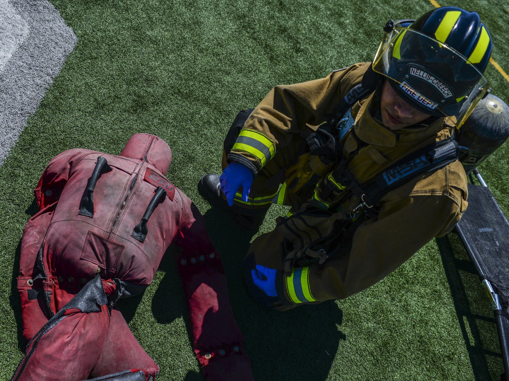 An Airman from the 99th Civil Engineer Squadron Fire Protection Flight checks a simulated victim for injuries before assigning a triage color during a base exercise at Nellis Air Force Base, Nev., May 12, 2016. Medical care is just one aspect of the extensive training that Air Force fire protection must undergo. (U.S. Air Force photo by Airman 1st Class Kevin Tanenbaum)