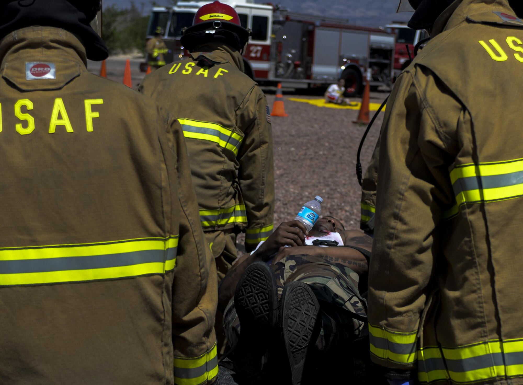 Members of the 99th Civil Engineer Squadron Fire Protection Flight carry a simulated victim on a stretcher during a base exercise at Nellis Air Force Base, Nev., May 12, 2016. This was one of the largest exercises at Nellis AFB and the scenarios were developed taking real-world events into account. (U.S. Air Force photo by Airman 1st Class Kevin Tanenbaum) 