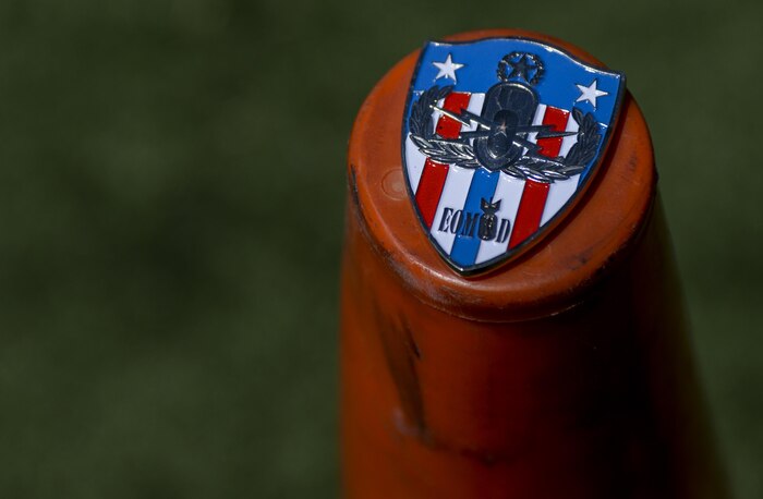 A 99th Civil Engineer Squadron explosive ordinance coin lays on a cone as an EOD technician prepares to X-Ray a suspicious package left at the scene of a simulated active shooter during a base exercise at Nellis Air Force Base, Nev., May 12, 2016. The coin is placed in the bottom corner of the X-ray and used for scale in determining how large the explosive is. (U.S. Air Force photo by Airman 1st Class Kevin Tanenbaum)