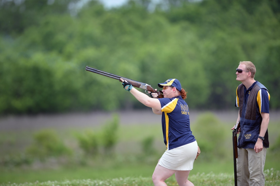 Navy Skeet Team member Lt. Meagan Makarenko shoots skeet as fellow team member Lt. Conor Stephens looks on during the 2016 Armed Services Skeet Championship. The competition was held May 9-13, 2016, at The Nashville Gun Club Tennessee Clay Target Complex near Nashville, Tennessee. DoD photo by Marvin D. Lynchard 