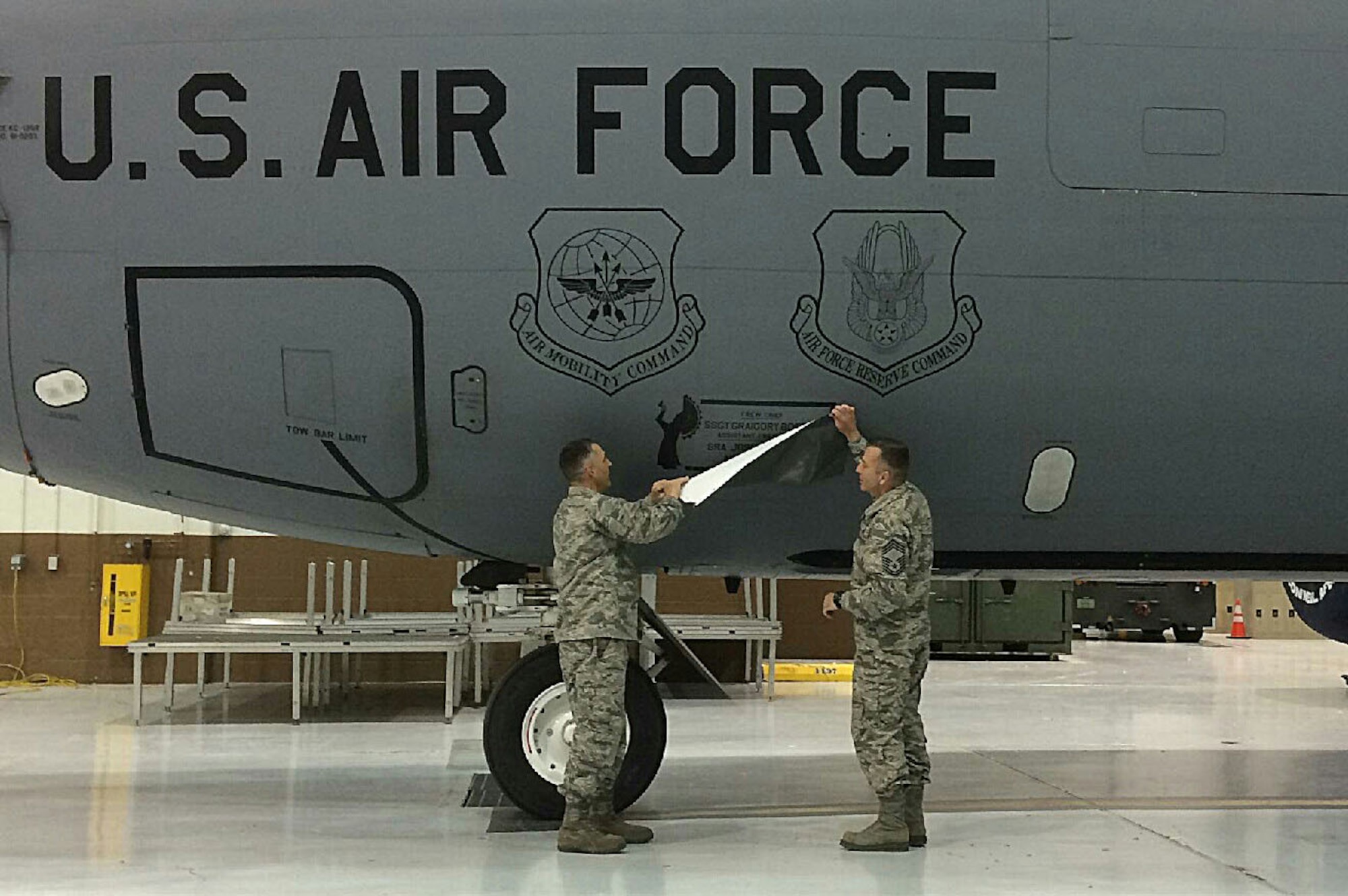 Lt. Col. Duane Richardson, 22nd Aircraft Maintenance Squadron commander, left, and Chief Master Sgt. Joseph Thomas, 22nd AMXS superintendent, reveal the dedicated crew chief box on a KC-135 Stratotanker, May 2, 2016, at McConnell Air Force Base, Kan. The 22nd AMXS and the 931st Aircraft Maintenance Squadron held a DCC Induction Ceremony where 58 DCC’s and assistant DCC’s were assigned to 25 KC-135 Stratotankers. (Courtesy photo)
